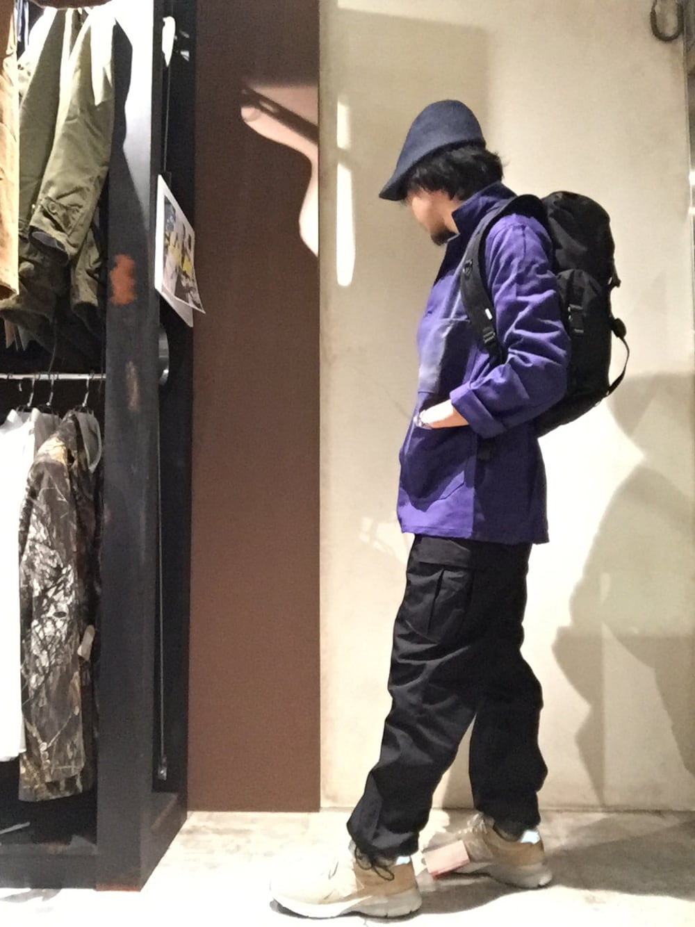 ブラック系のカーゴパンツ、ブラック系のバックパック/リュック、ブルー系のカバーオールを着用したメンズの秋コーディネートの1枚目の写真