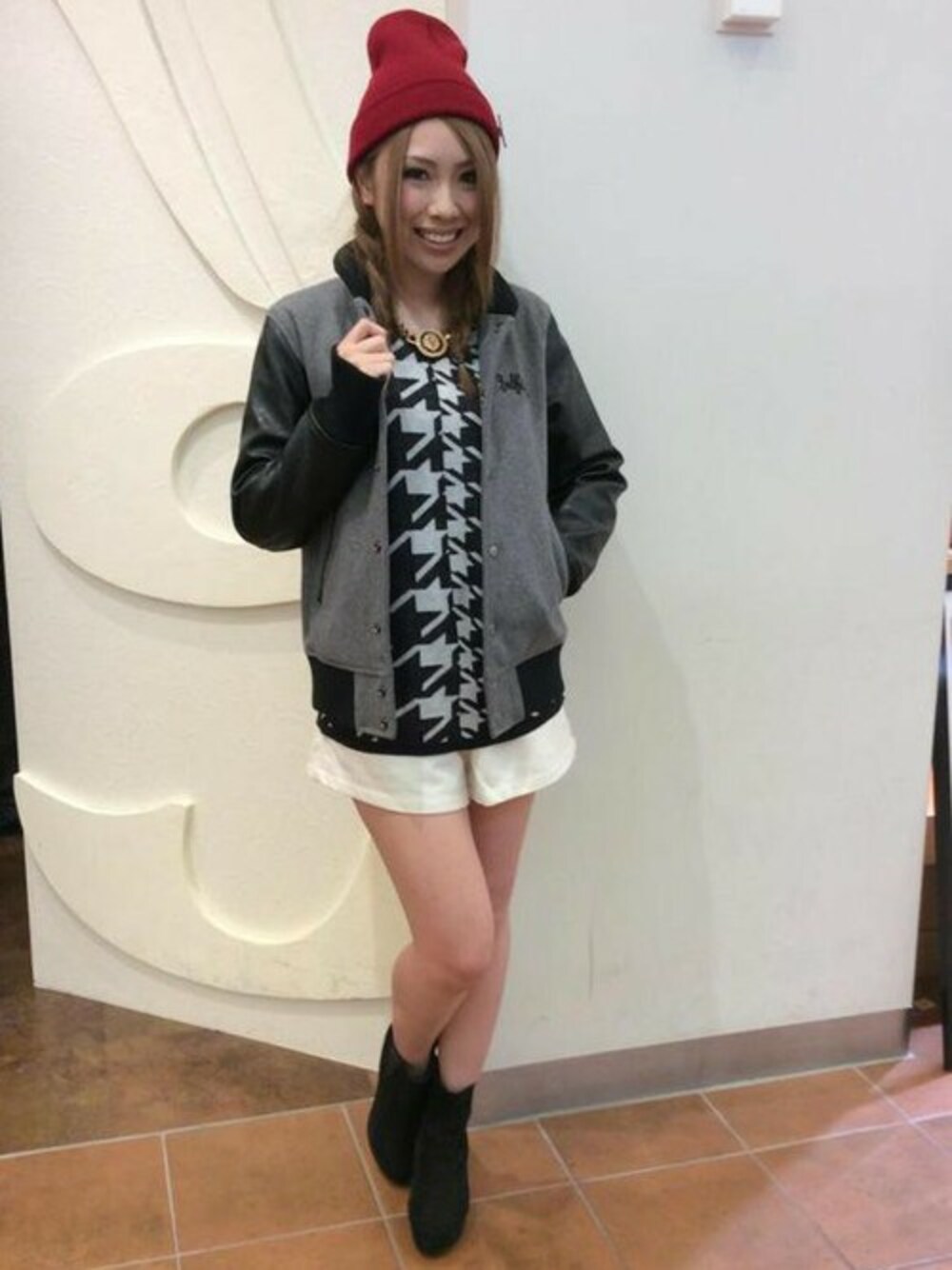 グレー系のスタジャン、ホワイト系のニット/セーター、ホワイト系のその他パンツを着用したレディースの秋コーディネートの1枚目の写真