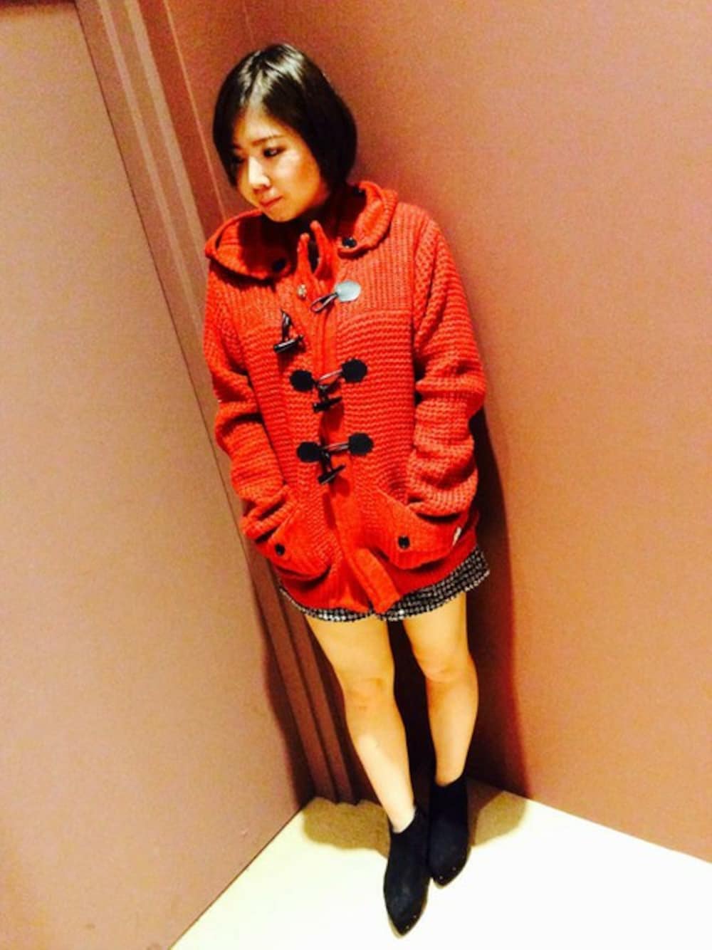 レッド系のダッフルコート、ブラック系のその他パンツ、ブラック系のブーツを着用したレディースの秋コーディネートの1枚目の写真