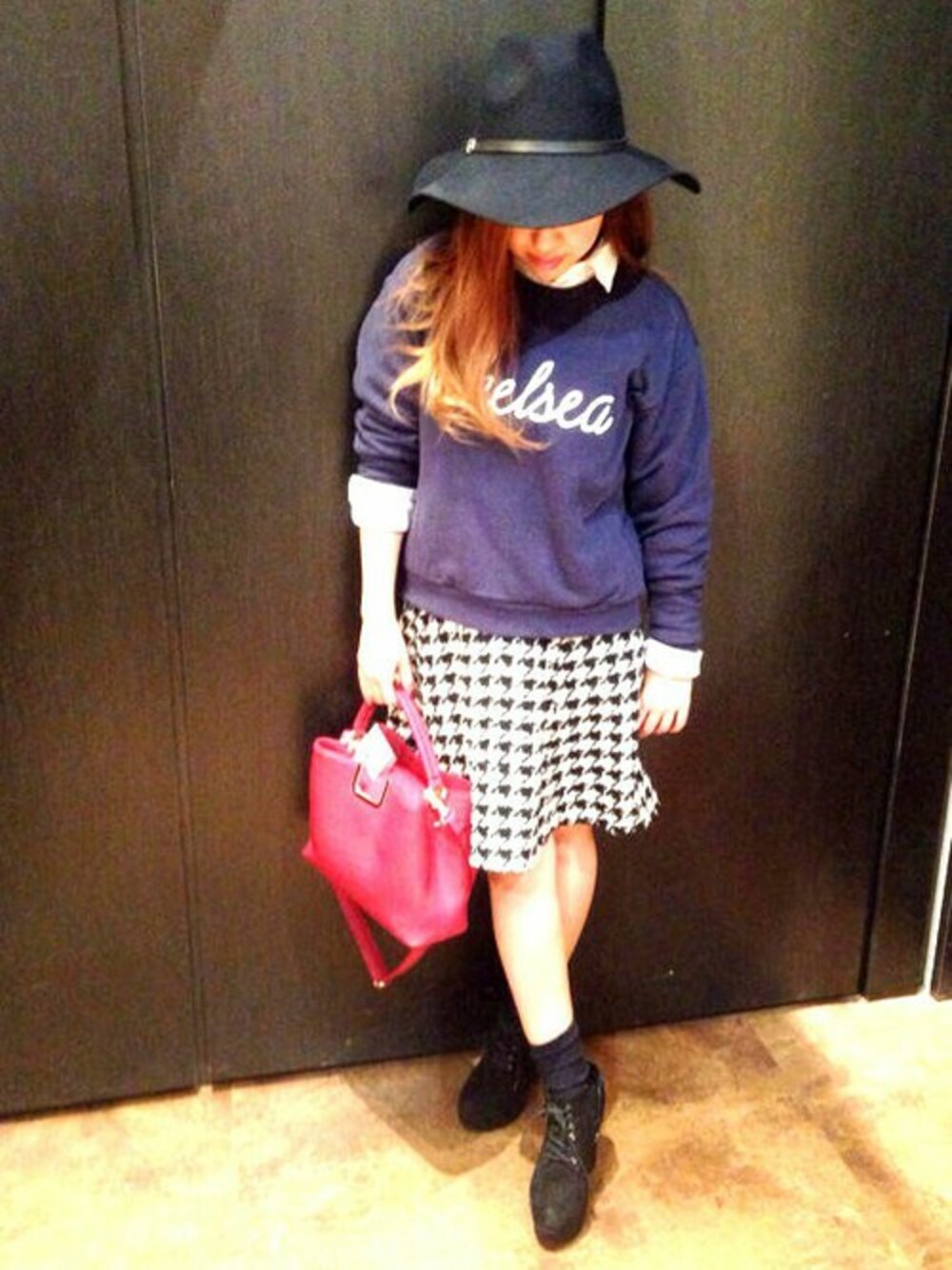 ブルー系のパーカー、ブラック系のスカート、レッド系のショルダーバッグを着用したレディースの秋コーディネートの1枚目の写真