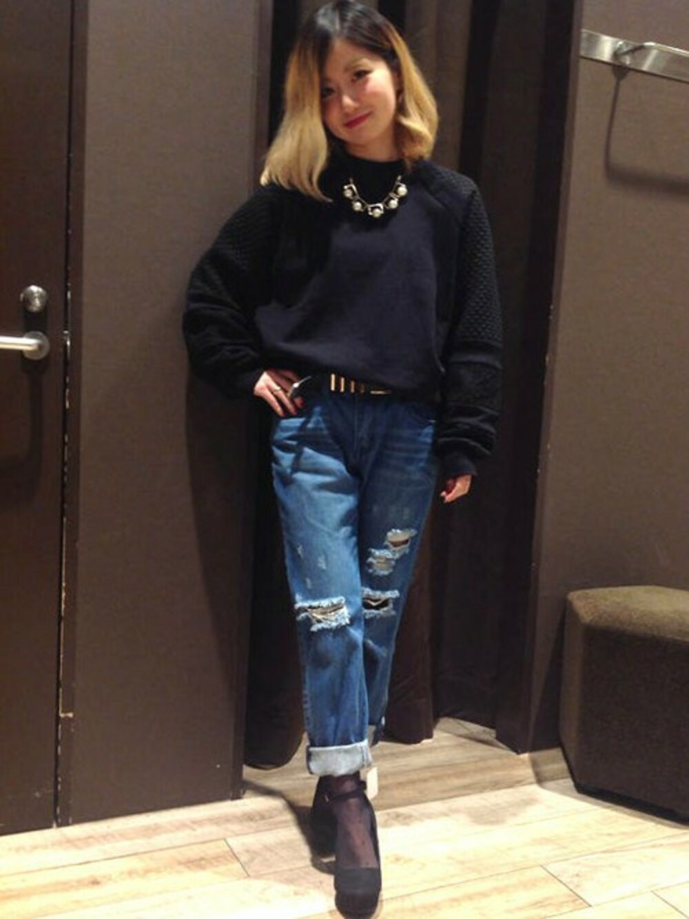 ブルー系のデニムパンツ、ブラック系のスウェット、ベージュ系のパンプスを着用したレディースの秋コーディネートの1枚目の写真