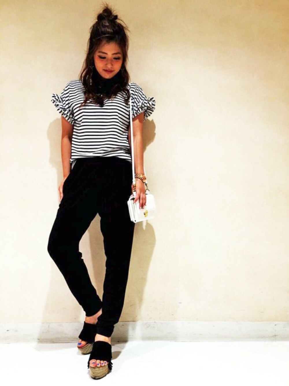 ホワイト系のショルダーバッグ、オレンジ系のTシャツ/カットソー、ブラック系のその他パンツを着用したレディースの夏コーディネートの1枚目の写真