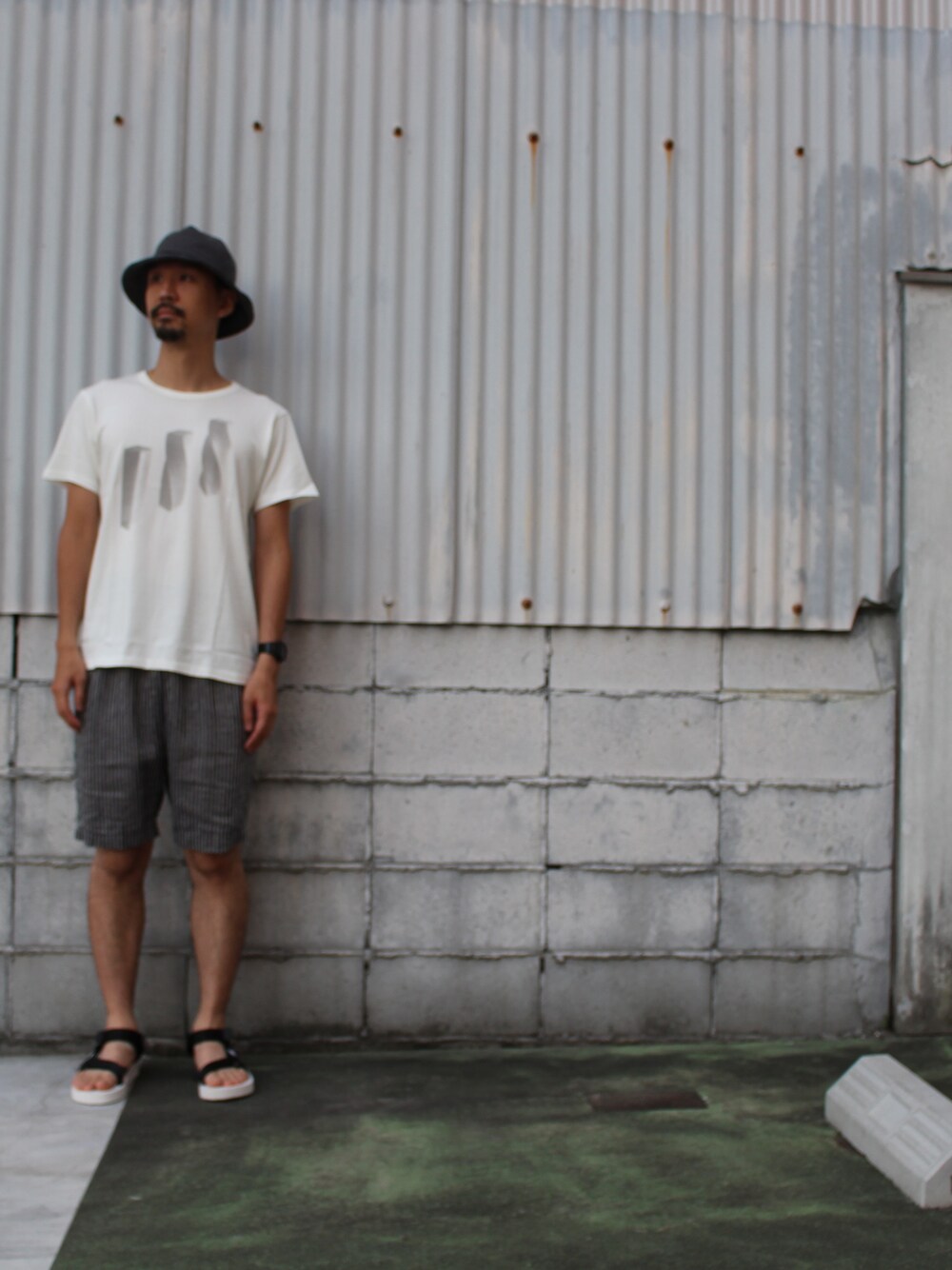 ホワイト系のTシャツ/カットソー、グレー系のその他パンツ、ホワイト系のサンダルを着用したメンズの夏コーディネートの1枚目の写真