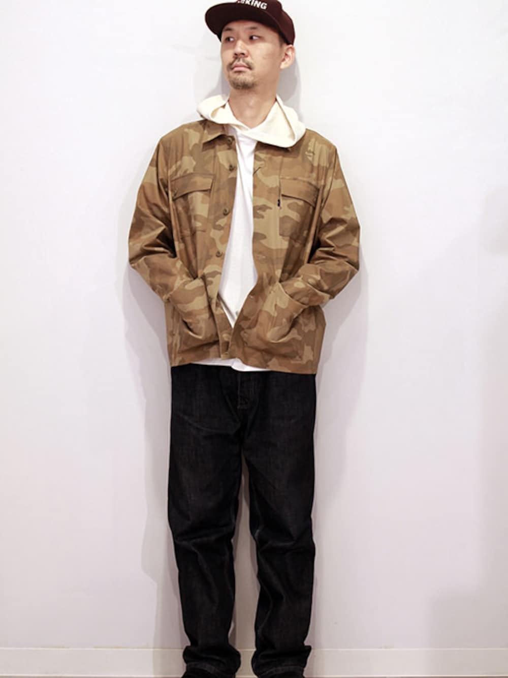 ベージュ系のカバーオール、その他のTシャツ/カットソー、ブラック系のスニーカーを着用したメンズの秋コーディネートの1枚目の写真