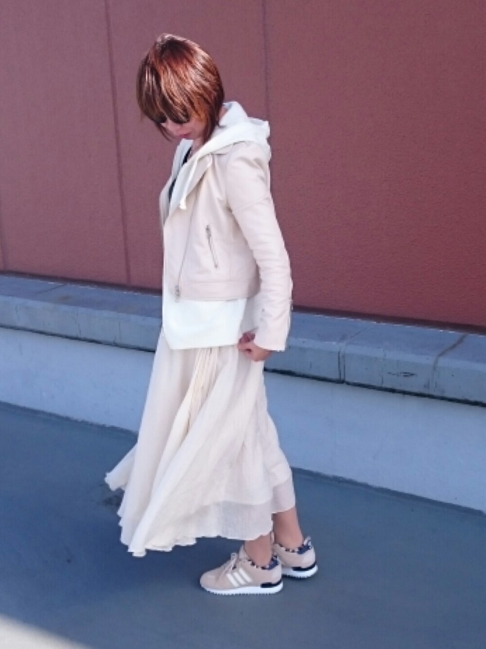 ベージュ系のスニーカー、ホワイト系のトップス、ホワイト系のスカートを着用したレディースの冬コーディネートの1枚目の写真