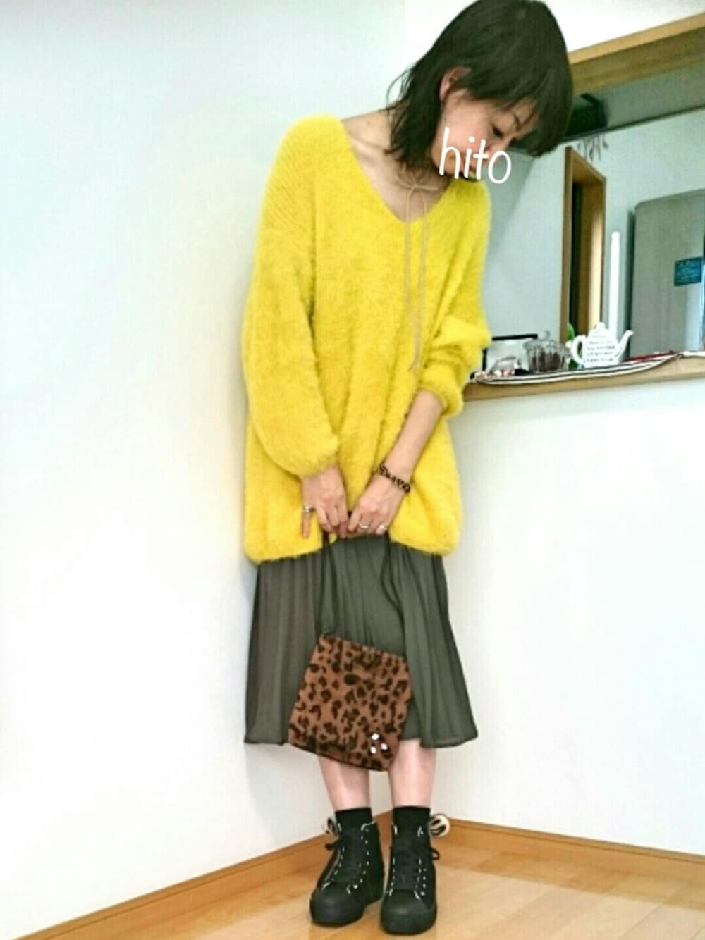 ブラウン系のバッグ、グリーン系のスカート、イエロー系のニット/セーターを着用したレディースの秋コーディネートの1枚目の写真