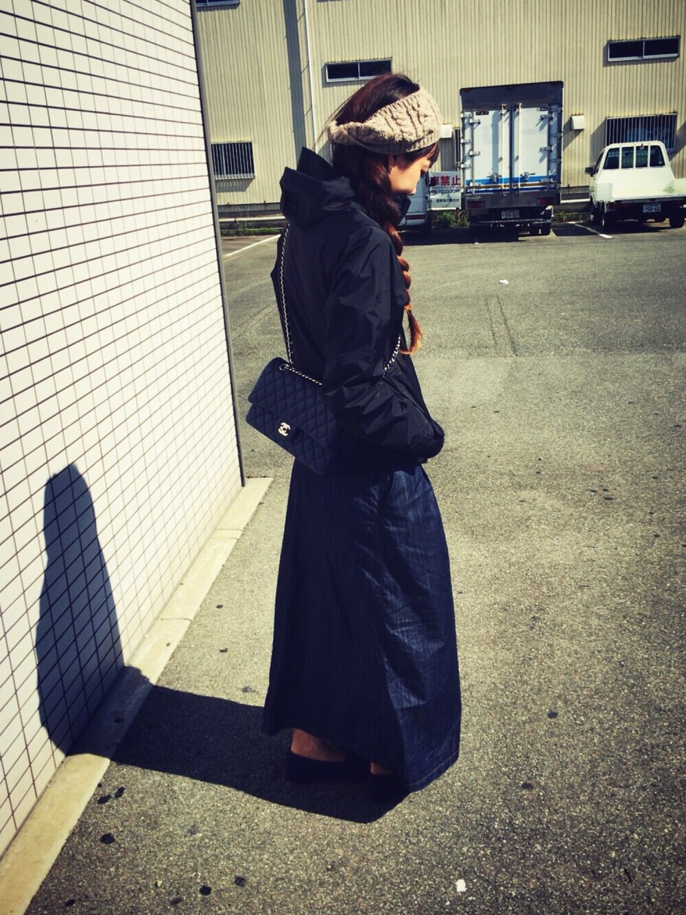 ブルー系のハンドバッグ、ブラック系のマウンテンパーカー、ブルー系のモカシン/デッキシューズを着用したレディースの秋コーディネートの1枚目の写真