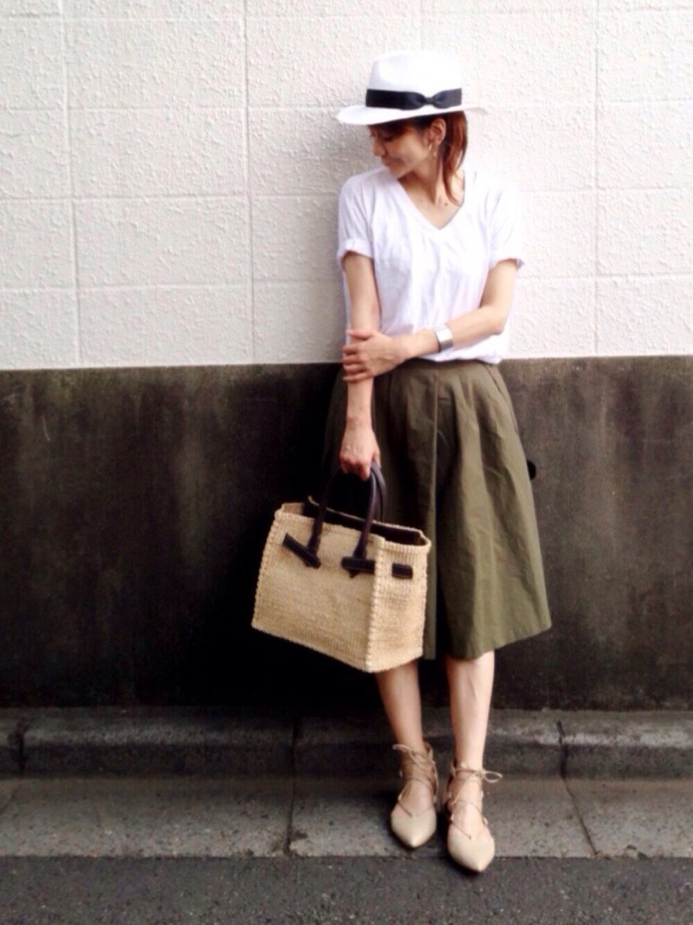 ホワイト系のTシャツ/カットソー、グリーン系のスカート、ベージュ系のかごバッグを着用したレディースの夏コーディネートの1枚目の写真