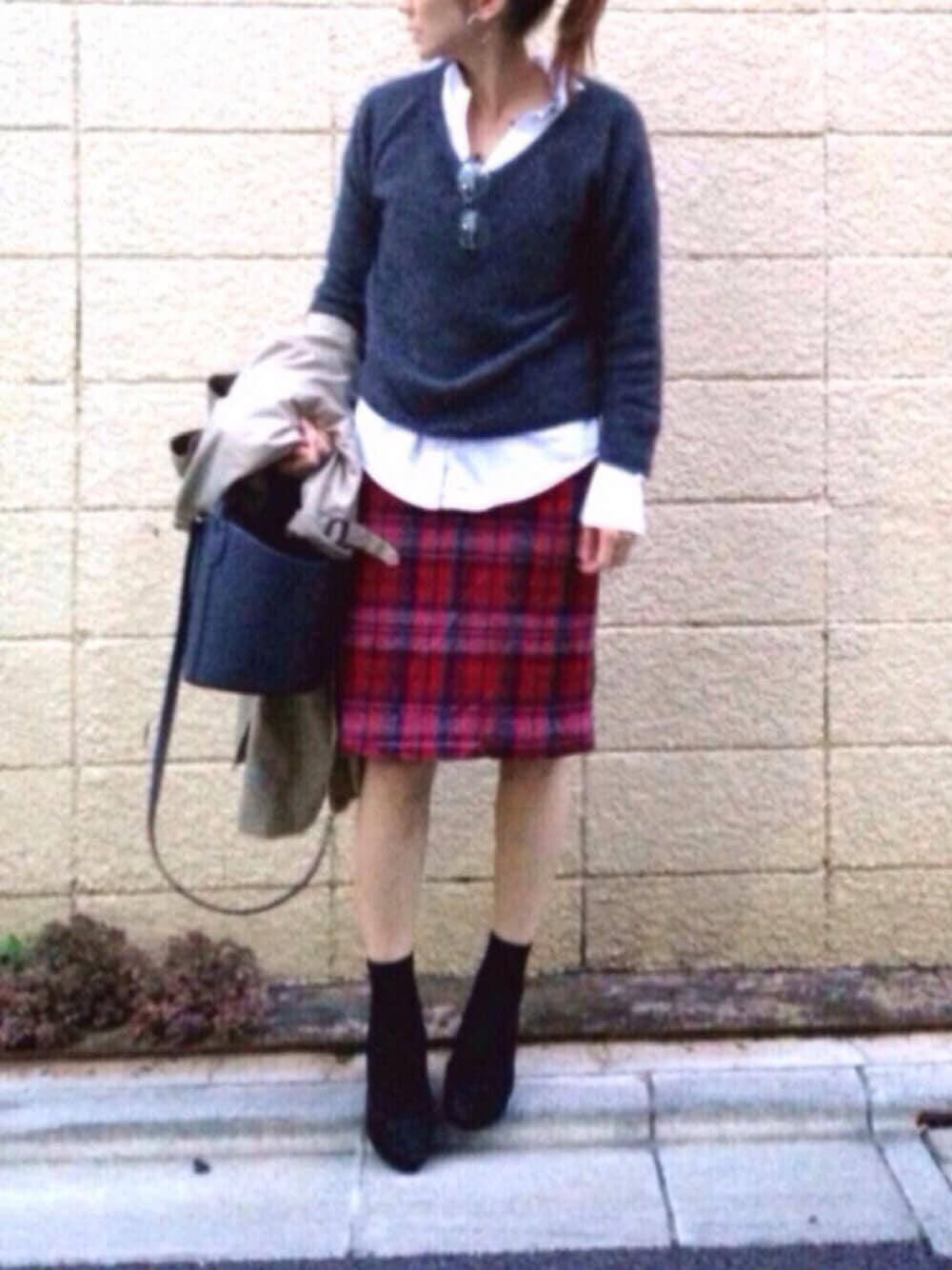 グレー系のニット/セーター、レッド系のスカート、ブラック系のパンプスを着用したレディースの秋コーディネートの1枚目の写真