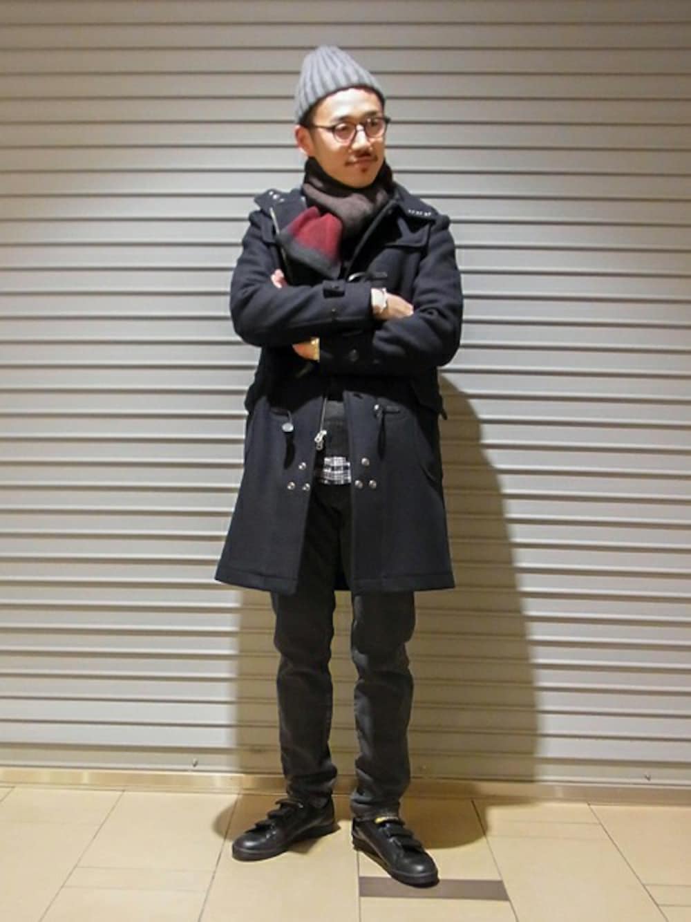 グレー系のニット/セーター、ブラック系のシャツ/ブラウス、ブラック系のスニーカーを着用したメンズの冬コーディネートの1枚目の写真