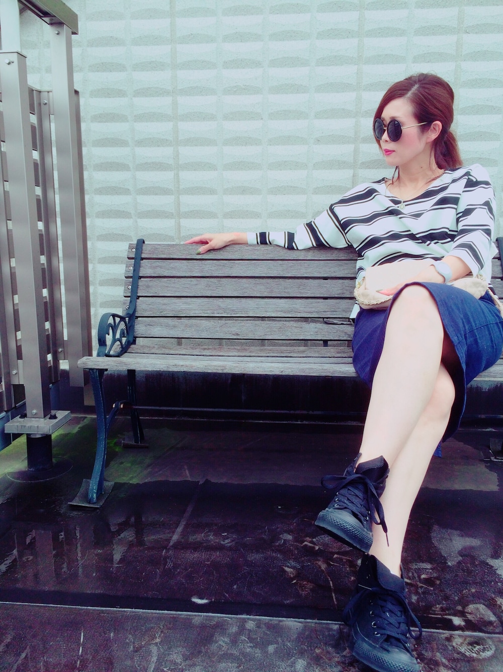 ホワイト系のTシャツ/カットソー、ブルー系のスカート、ブラック系のスニーカーを着用したレディースの秋コーディネートの1枚目の写真