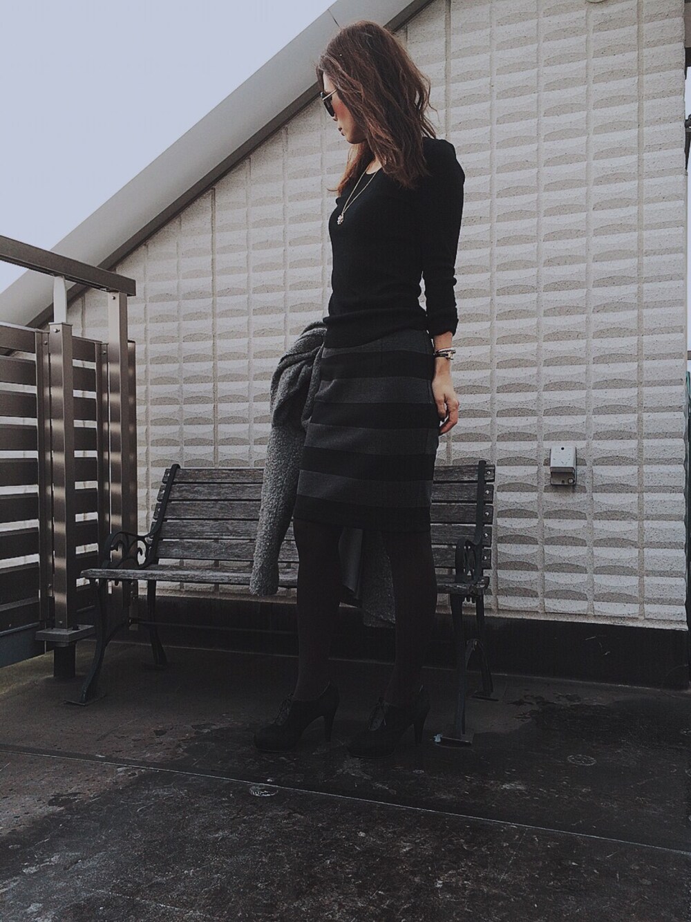 ブラック系のニット/セーター、ブラック系のスカート、グレー系のその他アウターを着用したレディースの冬コーディネートの1枚目の写真