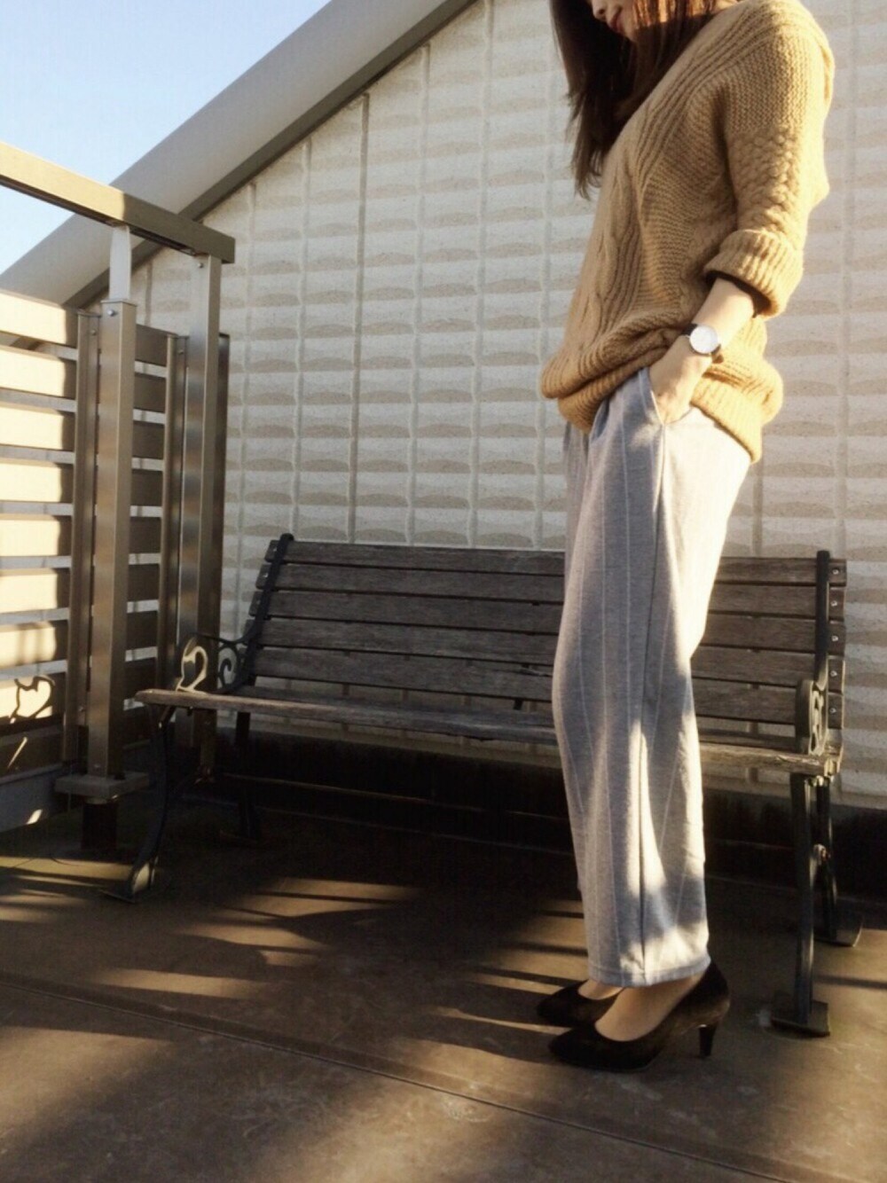 ブラウン系のニット/セーター、グレー系のその他パンツ、ブラック系のパンプスを着用したレディースの冬コーディネートの1枚目の写真