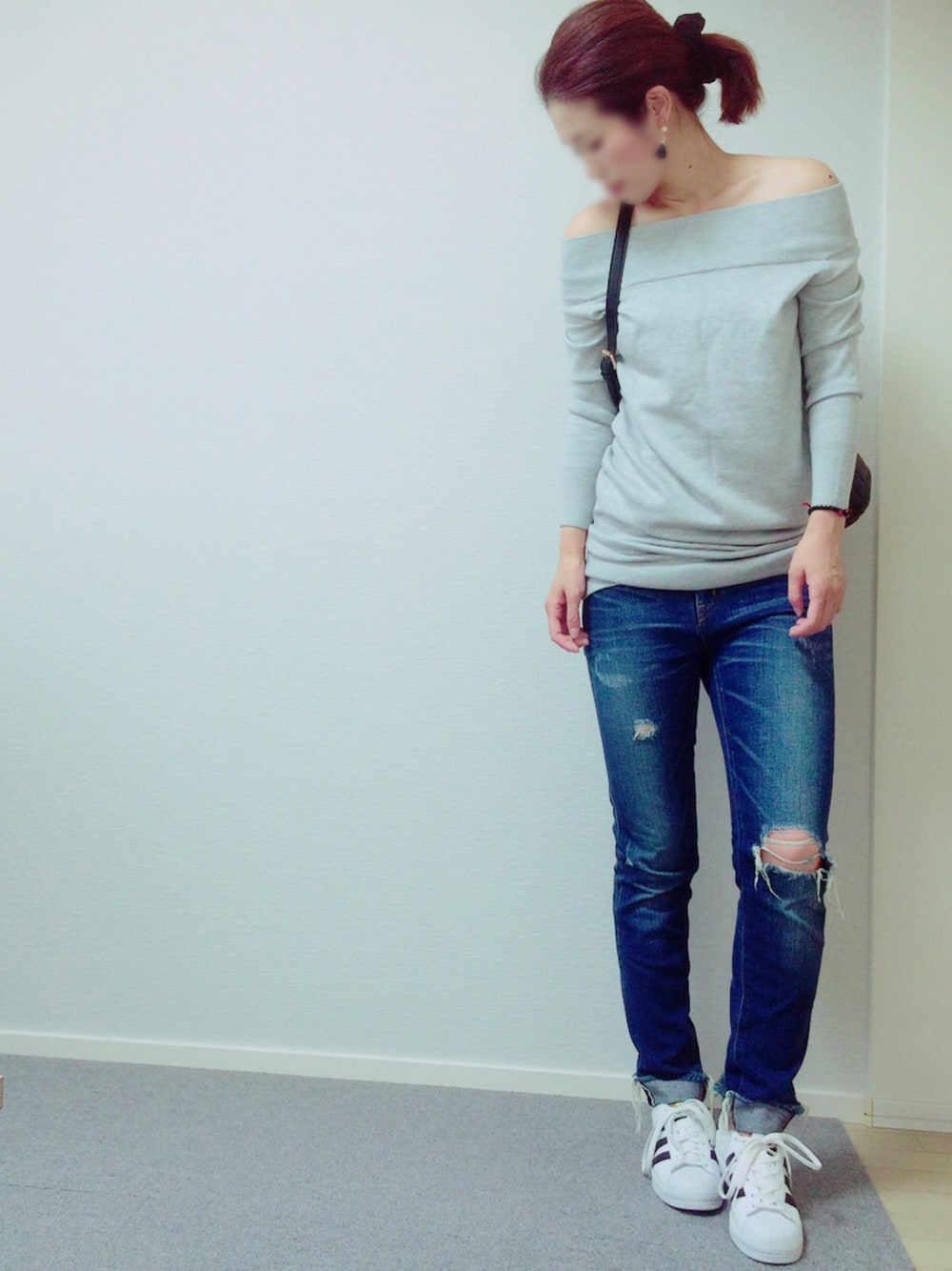 グレー系のワンピース、ブルー系のデニムパンツ、ホワイト系のスニーカーを着用したレディースの夏コーディネートの1枚目の写真