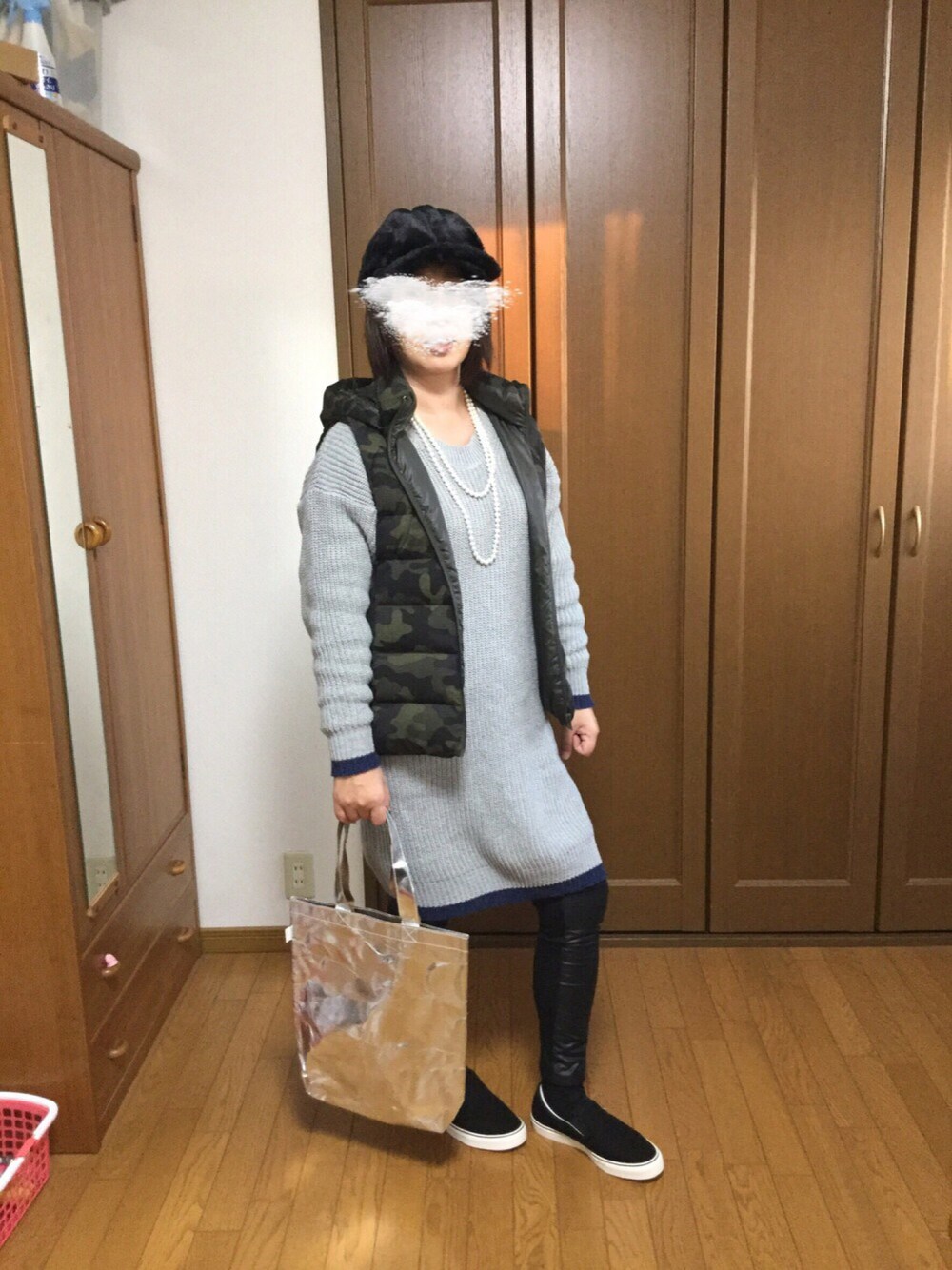 グレー系のワンピース、ブラック系のスニーカー、その他のダウンベストを着用したレディースの秋コーディネートの1枚目の写真