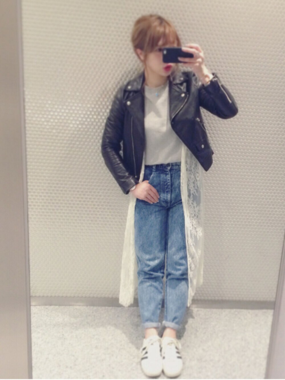 グレー系のTシャツ/カットソー、ブラック系のライダースジャケット、ブルー系のデニムパンツを着用したレディースの春コーディネートの1枚目の写真