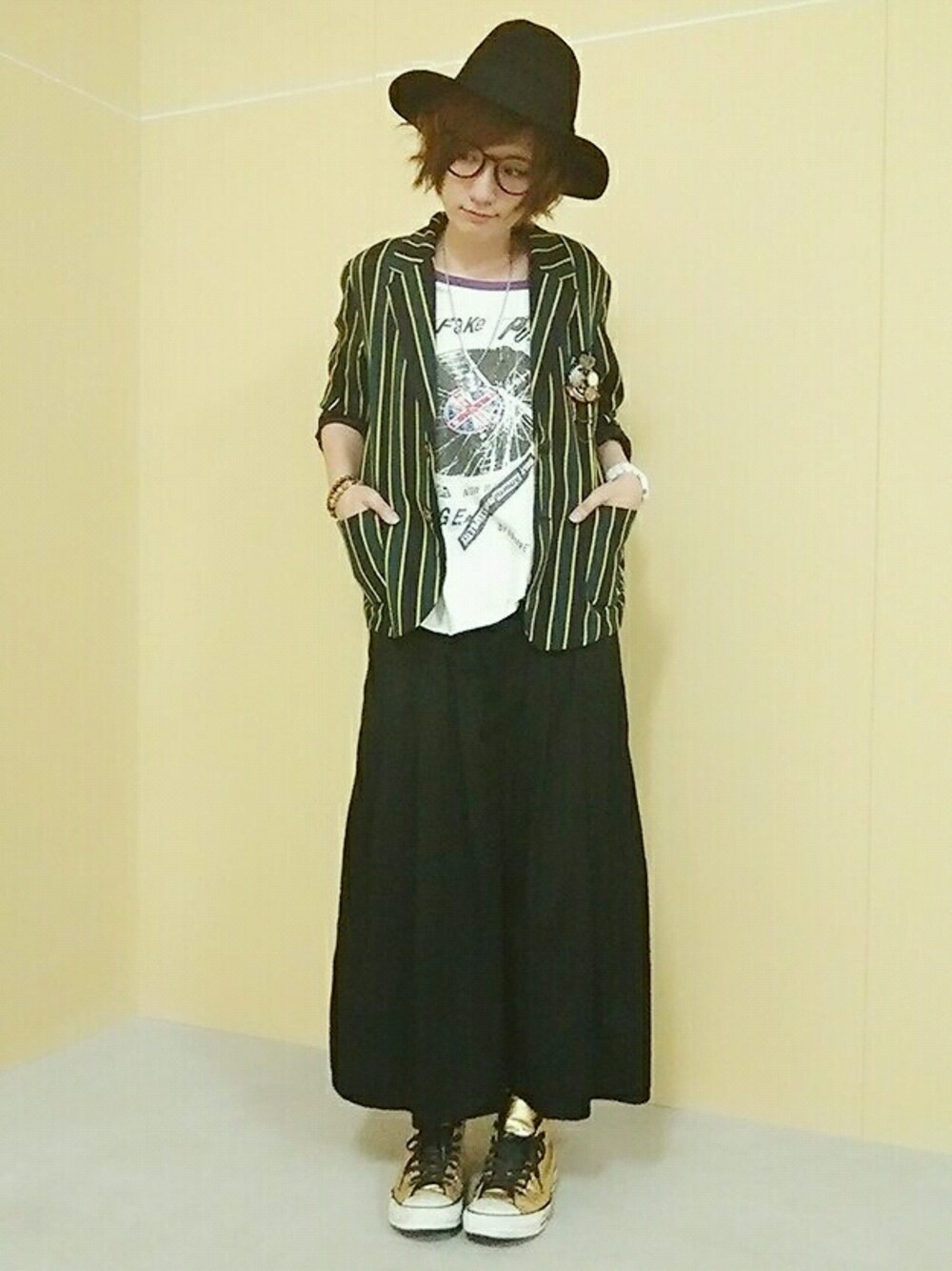 グリーン系のテーラードジャケット、ブラック系のパンツ、ゴールド系のシューズを着用したレディースの秋コーディネートの1枚目の写真