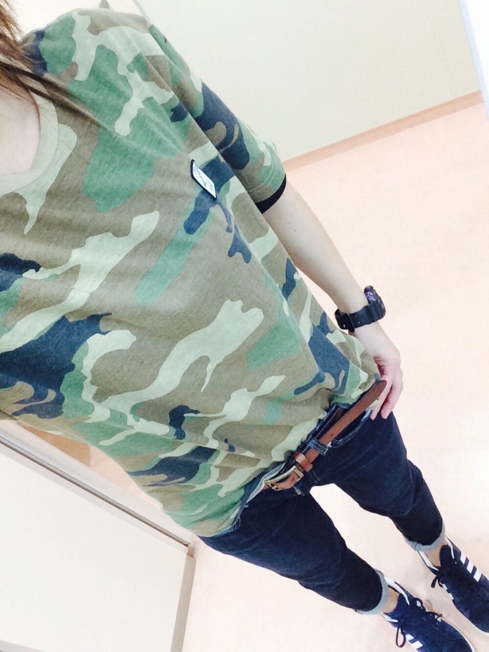 グリーン系のTシャツ/カットソー、ブルー系のスニーカー、ブラック系のベルトを着用したレディースの春コーディネートの1枚目の写真