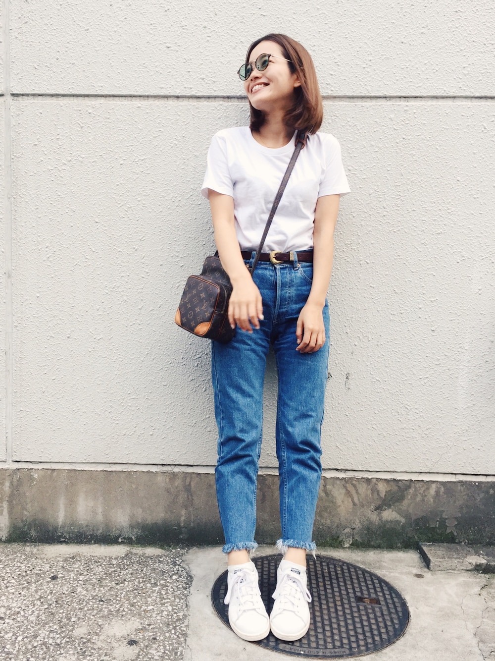 ホワイト系のTシャツ/カットソー、ブルー系のデニムパンツ、ブラック系のスニーカーを着用したレディースの夏コーディネートの1枚目の写真