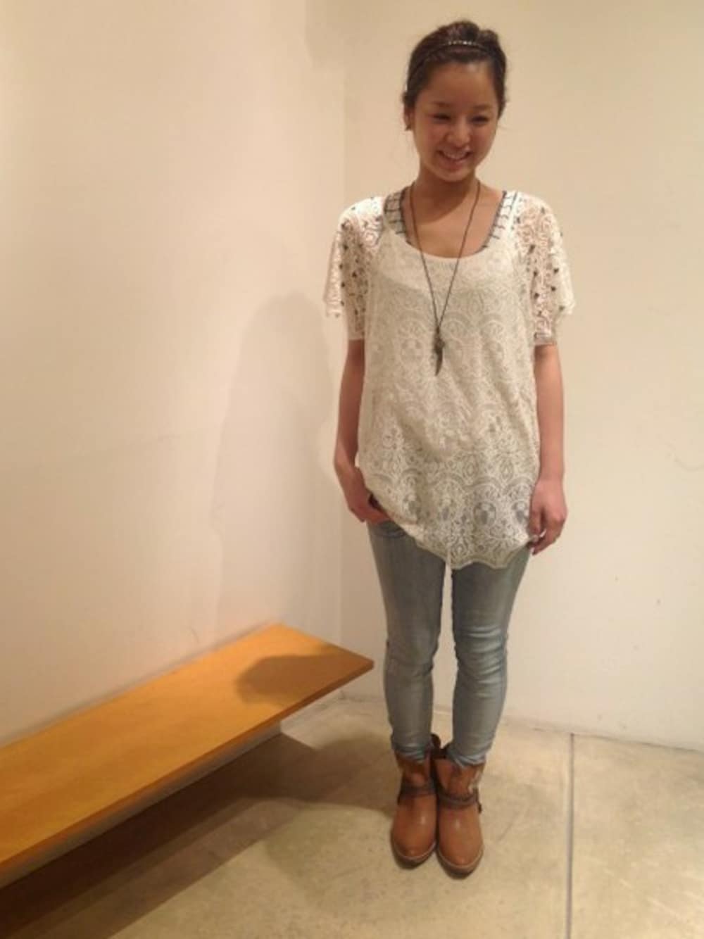 ホワイト系のチュニック、ブラウン系のブーツを着用したレディースの春コーディネートの1枚目の写真