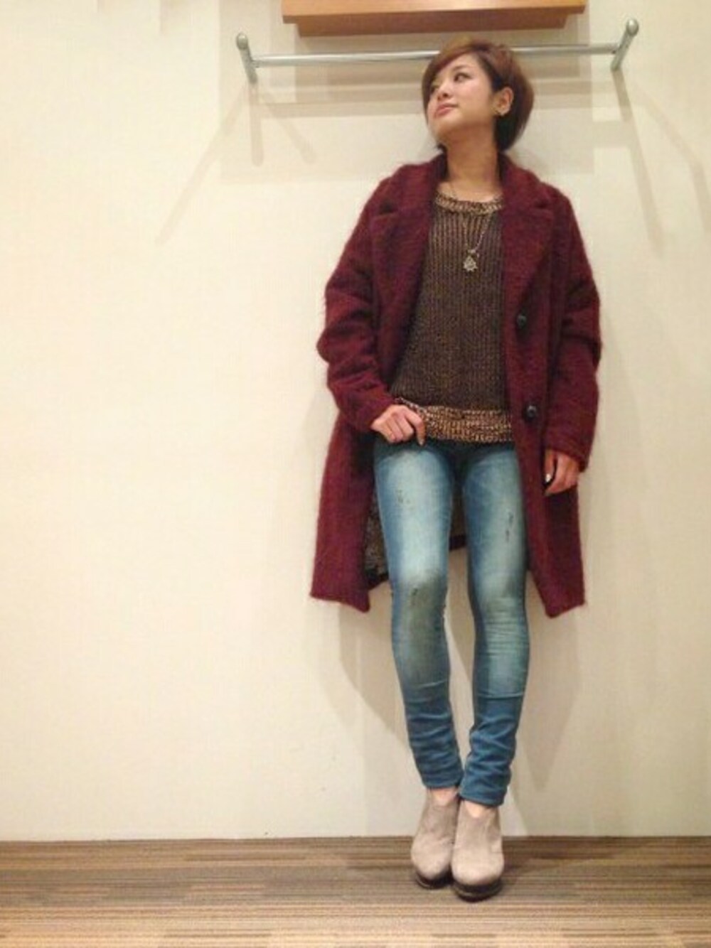 ブルー系のデニムパンツ、ブラック系のニット/セーター、レッド系のその他アウターを着用したレディースの秋コーディネートの1枚目の写真