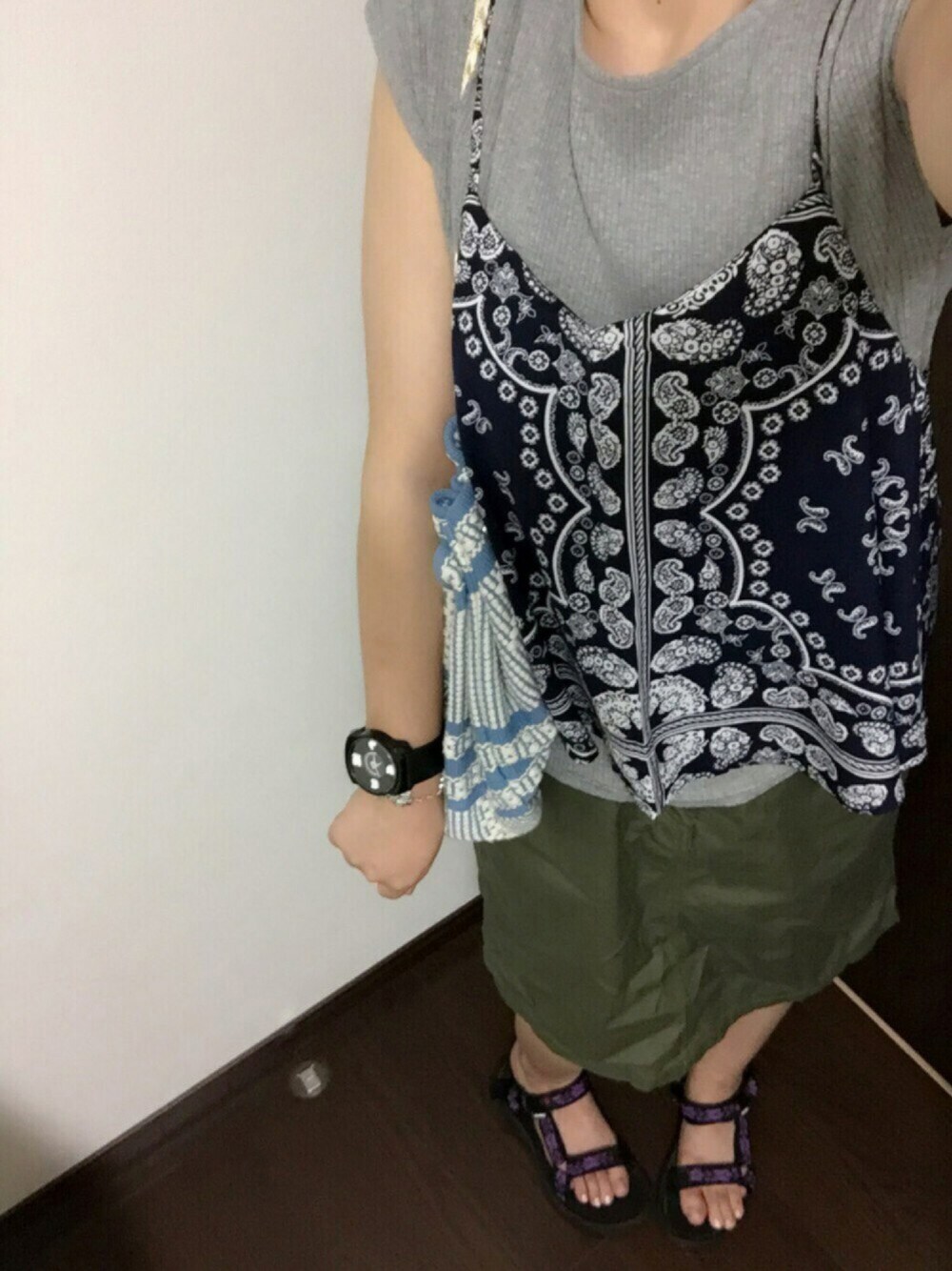 ブルー系のキャミソール、グリーン系のスカート、ブルー系のバッグを着用したレディースの夏コーディネートの1枚目の写真