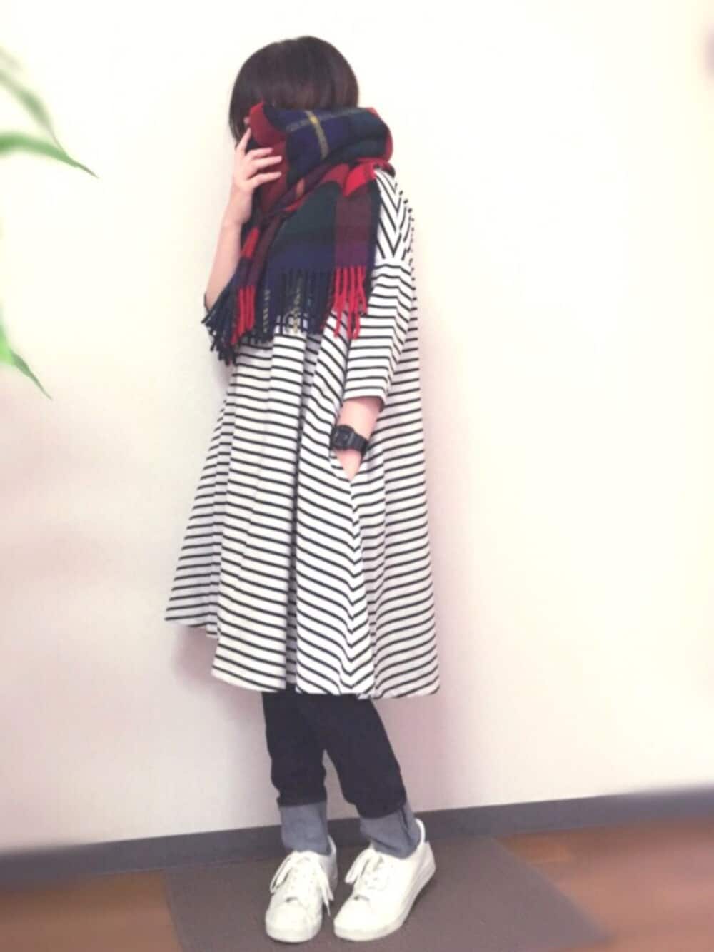 ホワイト系のスニーカー、ブルー系のデニムパンツ、その他のストール/ショールを着用したレディースの冬コーディネートの1枚目の写真