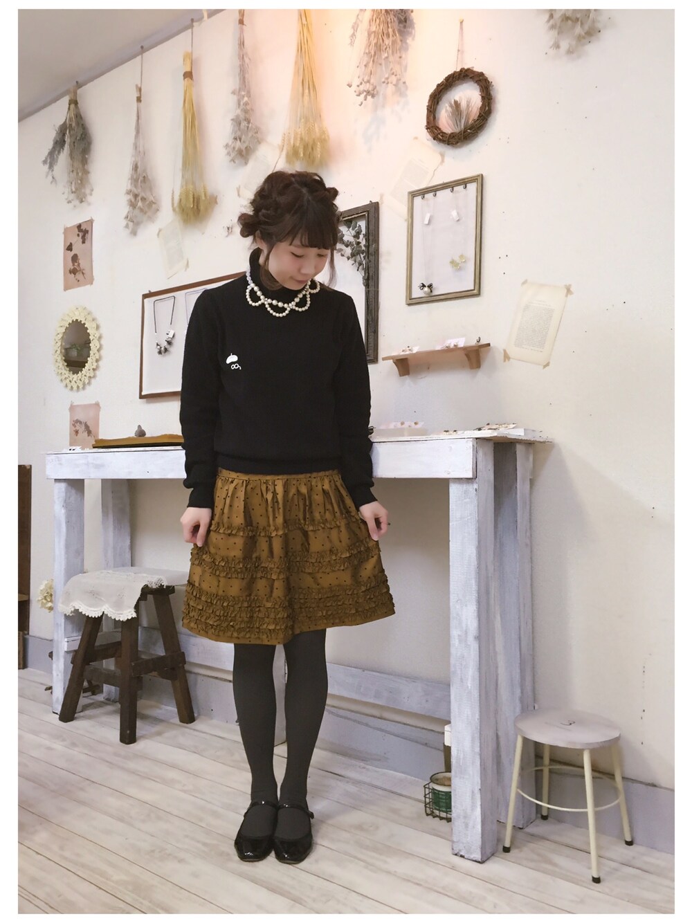 ブラック系のニット/セーター、ゴールド系のスカート、ブラック系のバレエシューズを着用したレディースの冬コーディネートの1枚目の写真