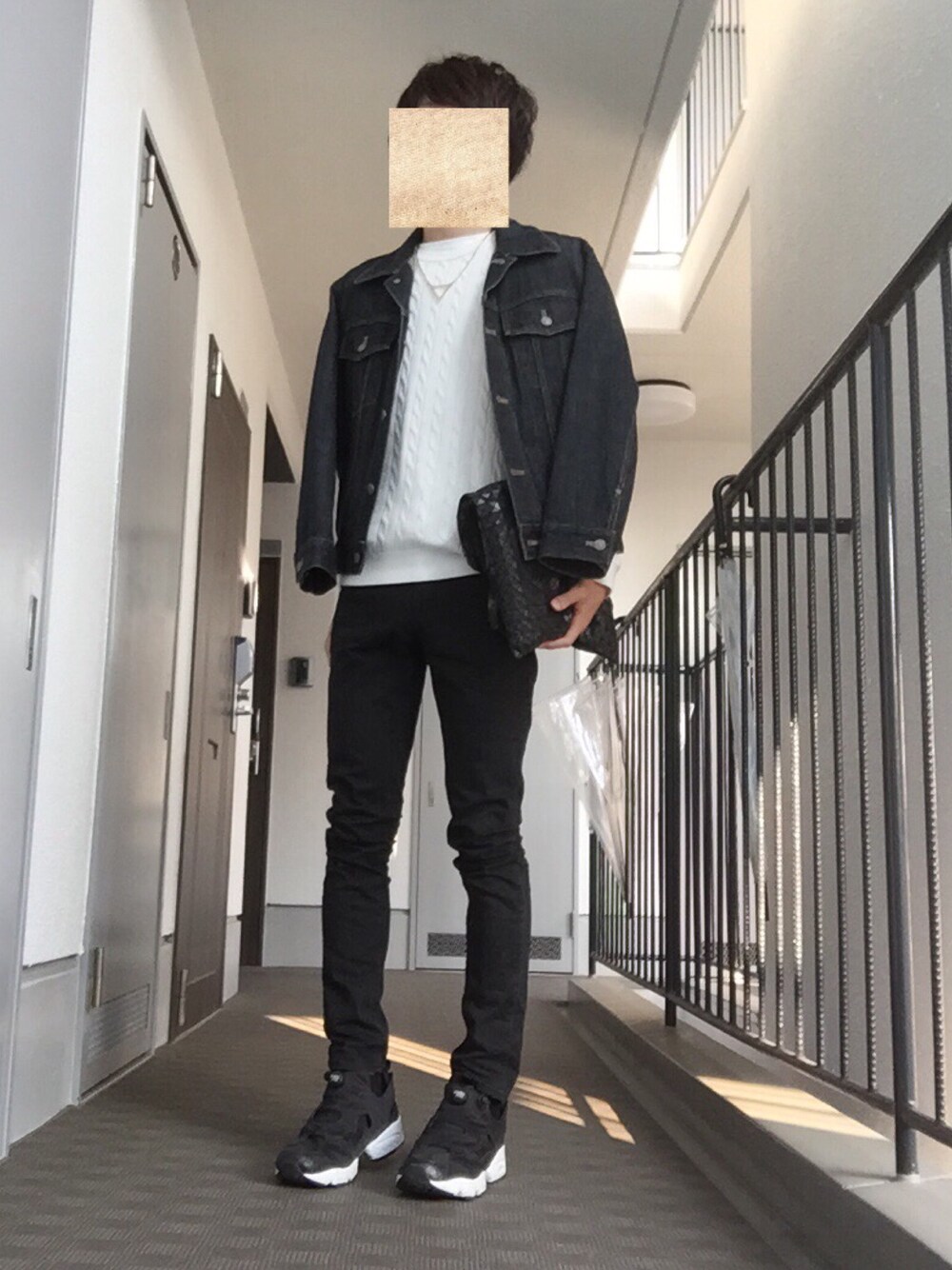 ブラック系のスニーカー、ブラック系のデニムパンツ、ブラック系のトートバッグを着用したメンズの秋コーディネートの1枚目の写真