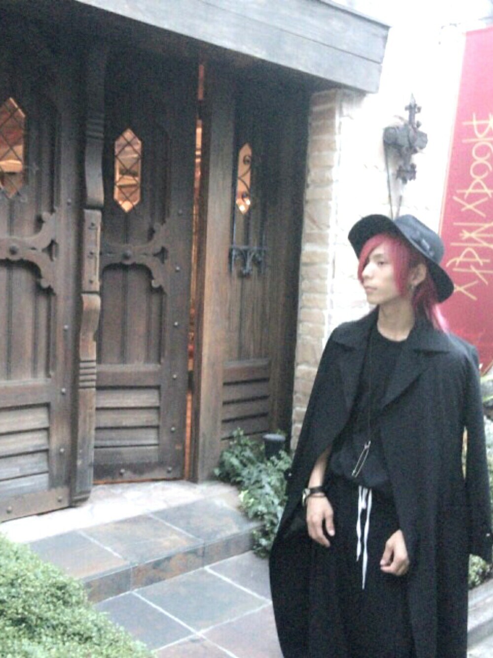 ブラック系のトレンチコート、ブラック系のTシャツ/カットソー、ブラック系のパンツを着用したメンズの秋コーディネートの1枚目の写真