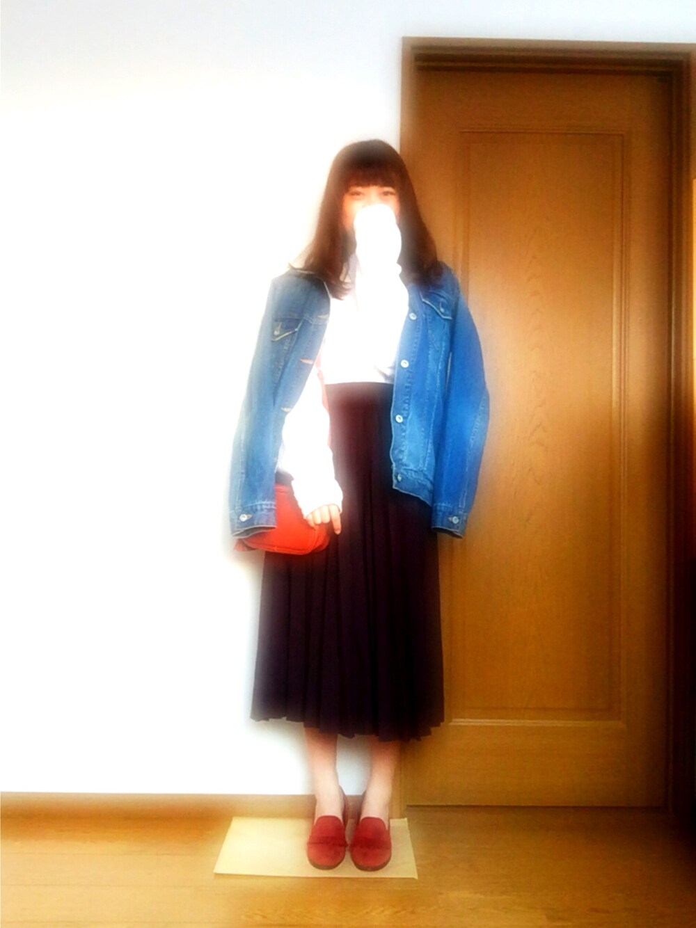 ホワイト系のトップス、ブルー系のデニムジャケット、レッド系のショルダーバッグを着用したレディースの冬コーディネートの1枚目の写真