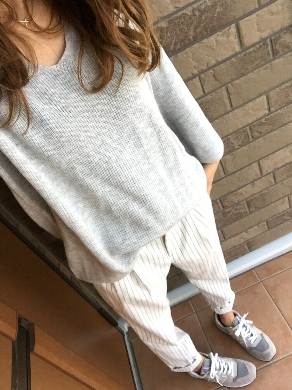 グレー系のニット/セーター、グレー系のスニーカー、ホワイト系のその他パンツを着用したレディースの冬コーディネートの1枚目の写真