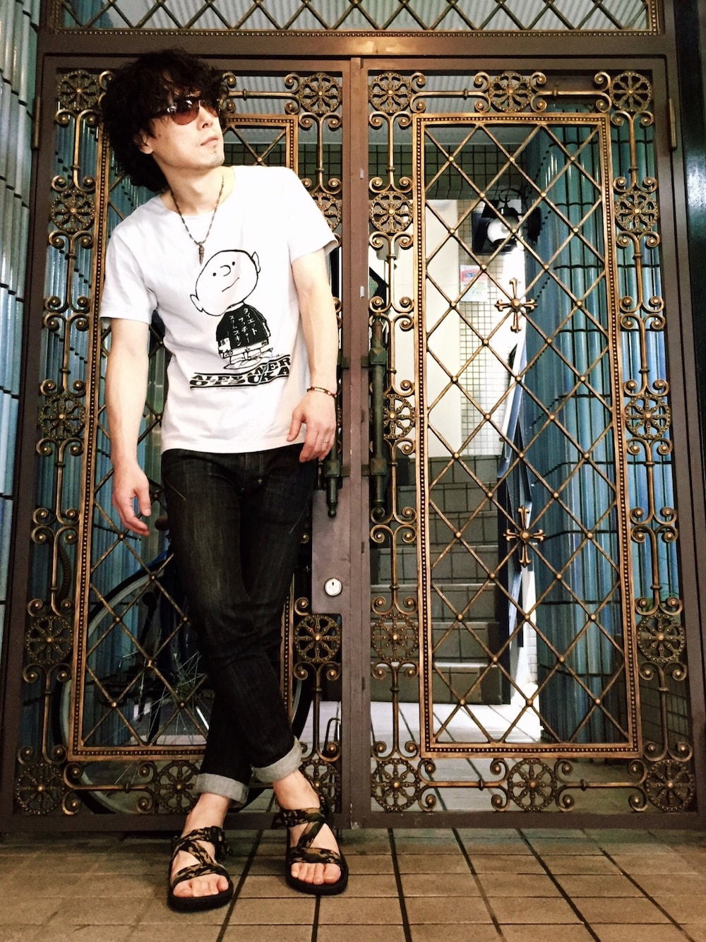 グレー系のTシャツ/カットソー、その他のサンダル、ブラック系のデニムパンツを着用したメンズの夏コーディネートの1枚目の写真