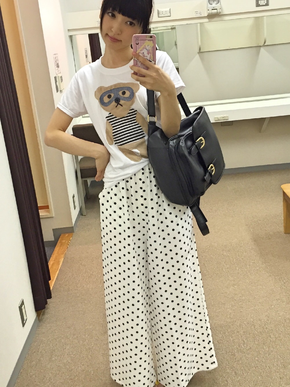 ホワイト系のスラックス、ブラック系のバックパック/リュック、ホワイト系のTシャツ/カットソーを着用したレディースの夏コーディネートの1枚目の写真