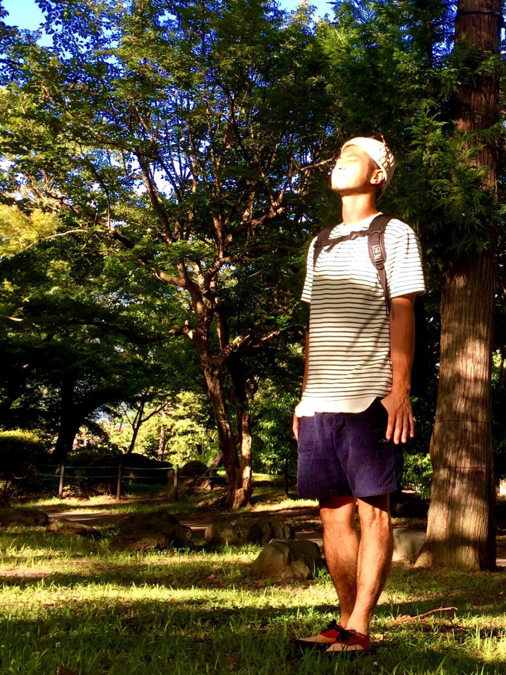 ブラック系のバックパック/リュック、ホワイト系のTシャツ/カットソー、ブルー系のパンツを着用したメンズの夏コーディネートの1枚目の写真