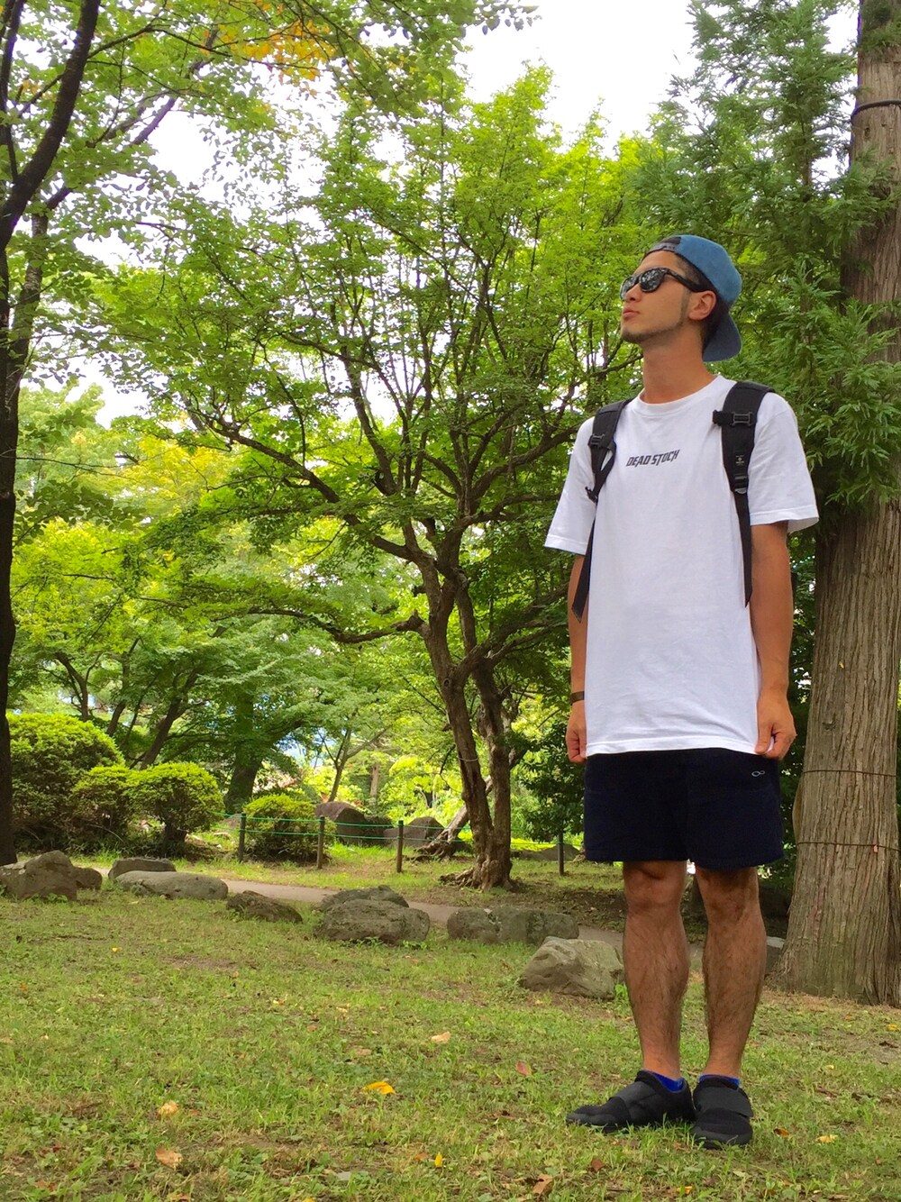 ホワイト系のTシャツ/カットソー、ブルー系のパンツ、ブラック系のスニーカーを着用したメンズの夏コーディネートの1枚目の写真