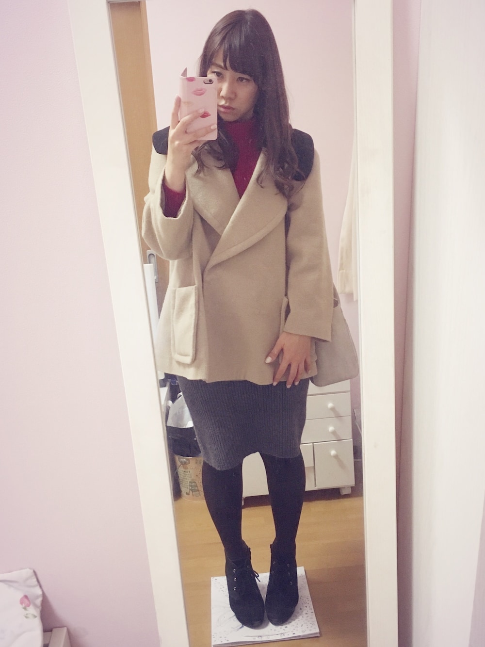 グレー系のスカート、レッド系のニット/セーター、ベージュ系のその他アウターを着用したレディースの冬コーディネートの1枚目の写真