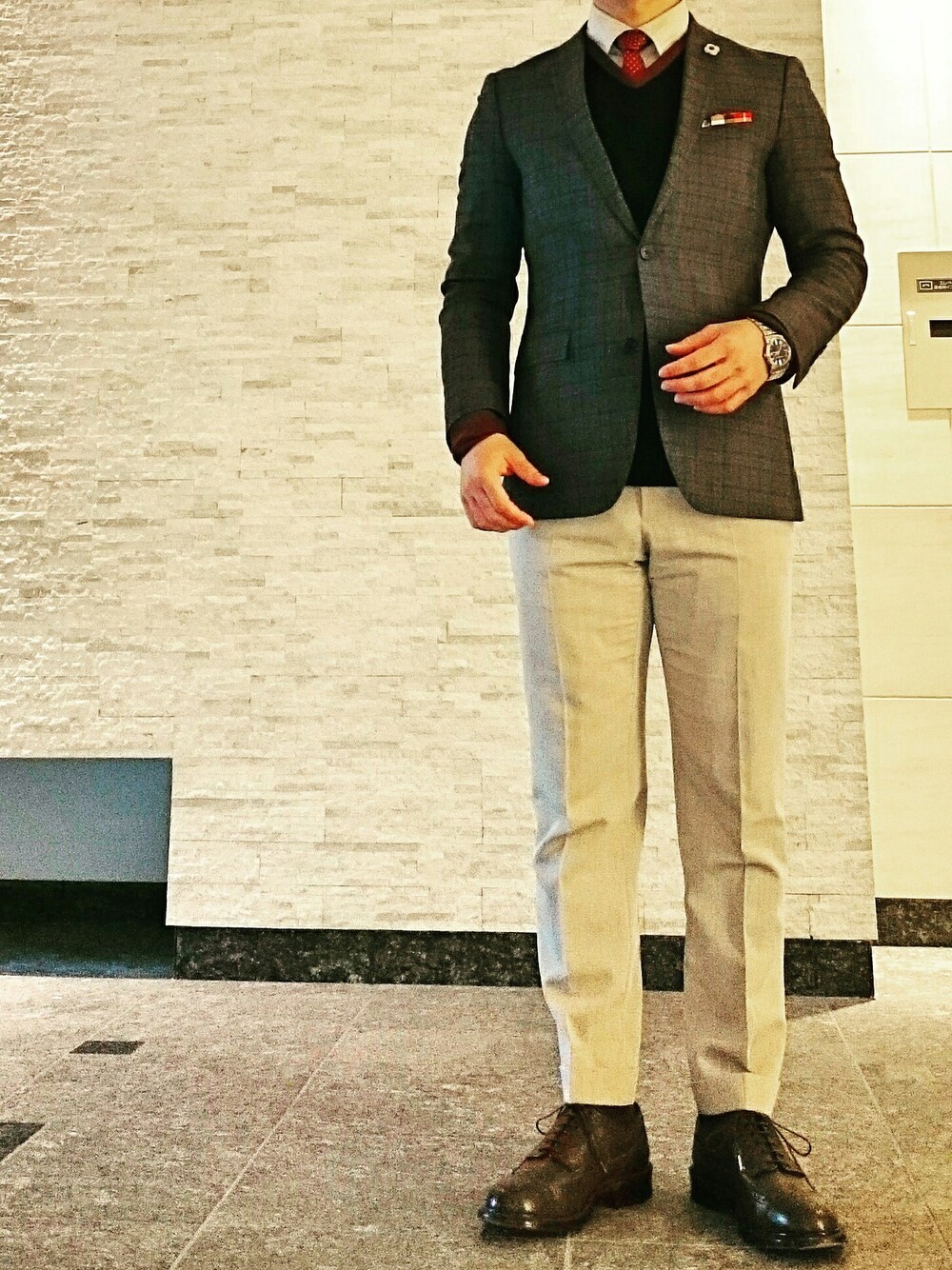 ベージュ系のスラックス、ブラウン系のシューズ、グレー系のスーツジャケットを着用したメンズの冬コーディネートの1枚目の写真