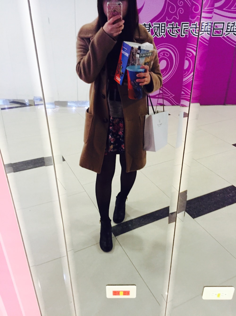 ブラウン系のチェスターコート、ブラック系のブーツを着用したレディースの春コーディネートの1枚目の写真