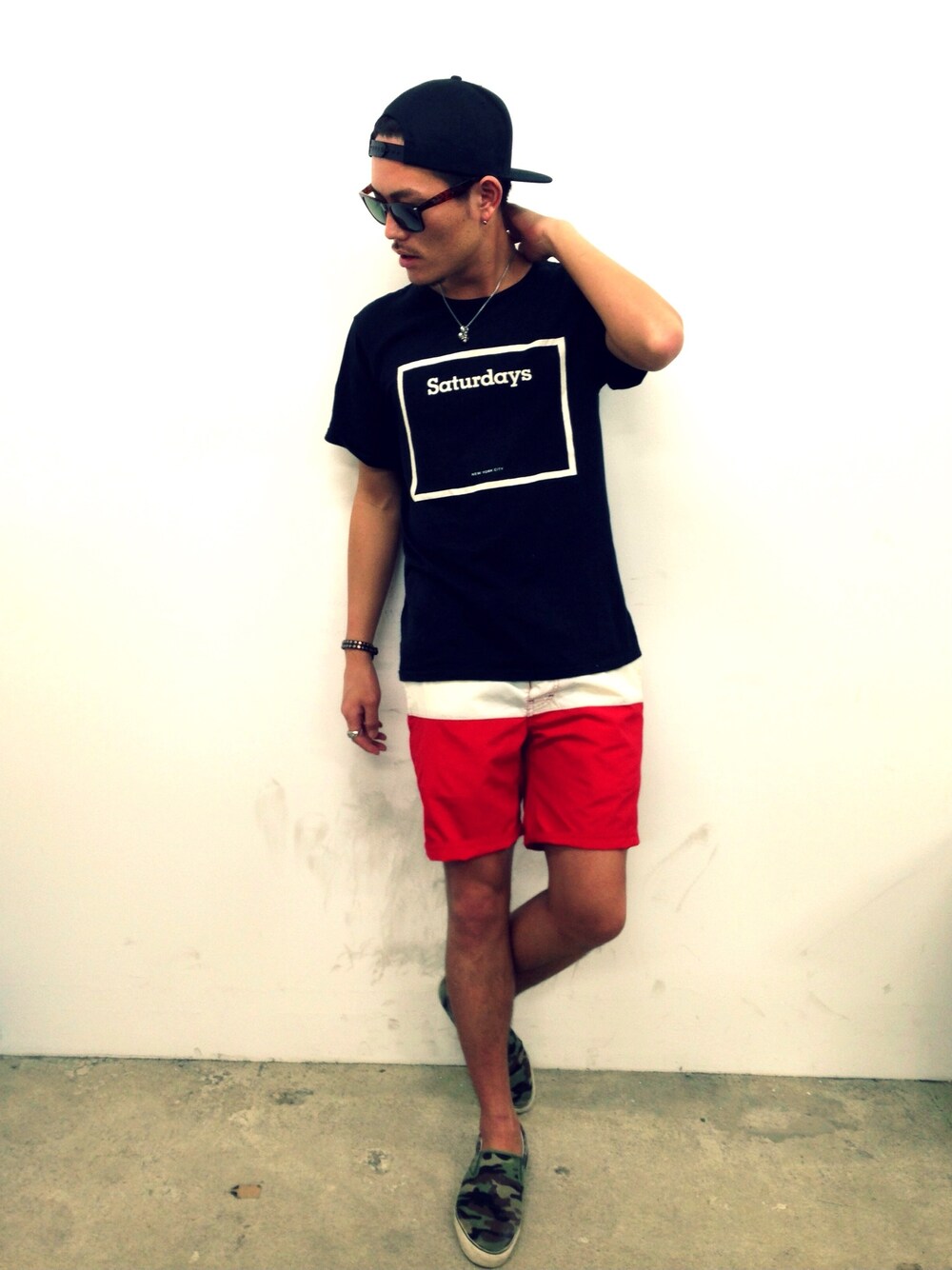 ブラック系のTシャツ/カットソー、グリーン系のスニーカー、ブラック系のキャップを着用したメンズの春コーディネートの1枚目の写真