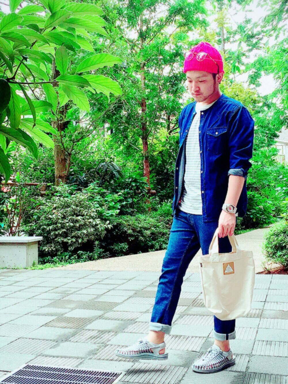 グレー系のサンダル、ブルー系のデニムパンツ、ホワイト系のトートバッグを着用したメンズの夏コーディネートの1枚目の写真