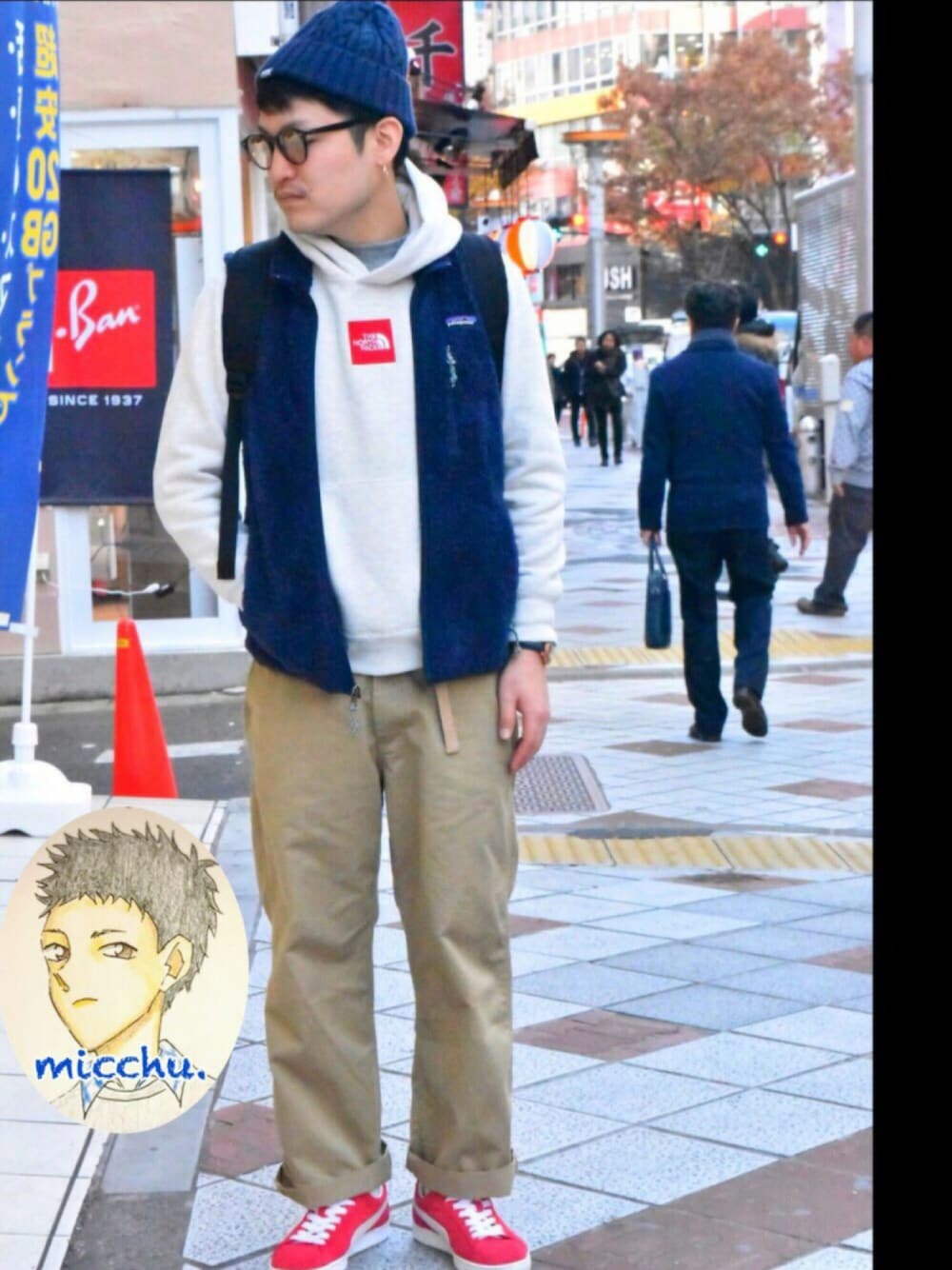 ホワイト系のパーカー、ブルー系のベスト、ベージュ系のチノパンツを着用したメンズの冬コーディネートの1枚目の写真