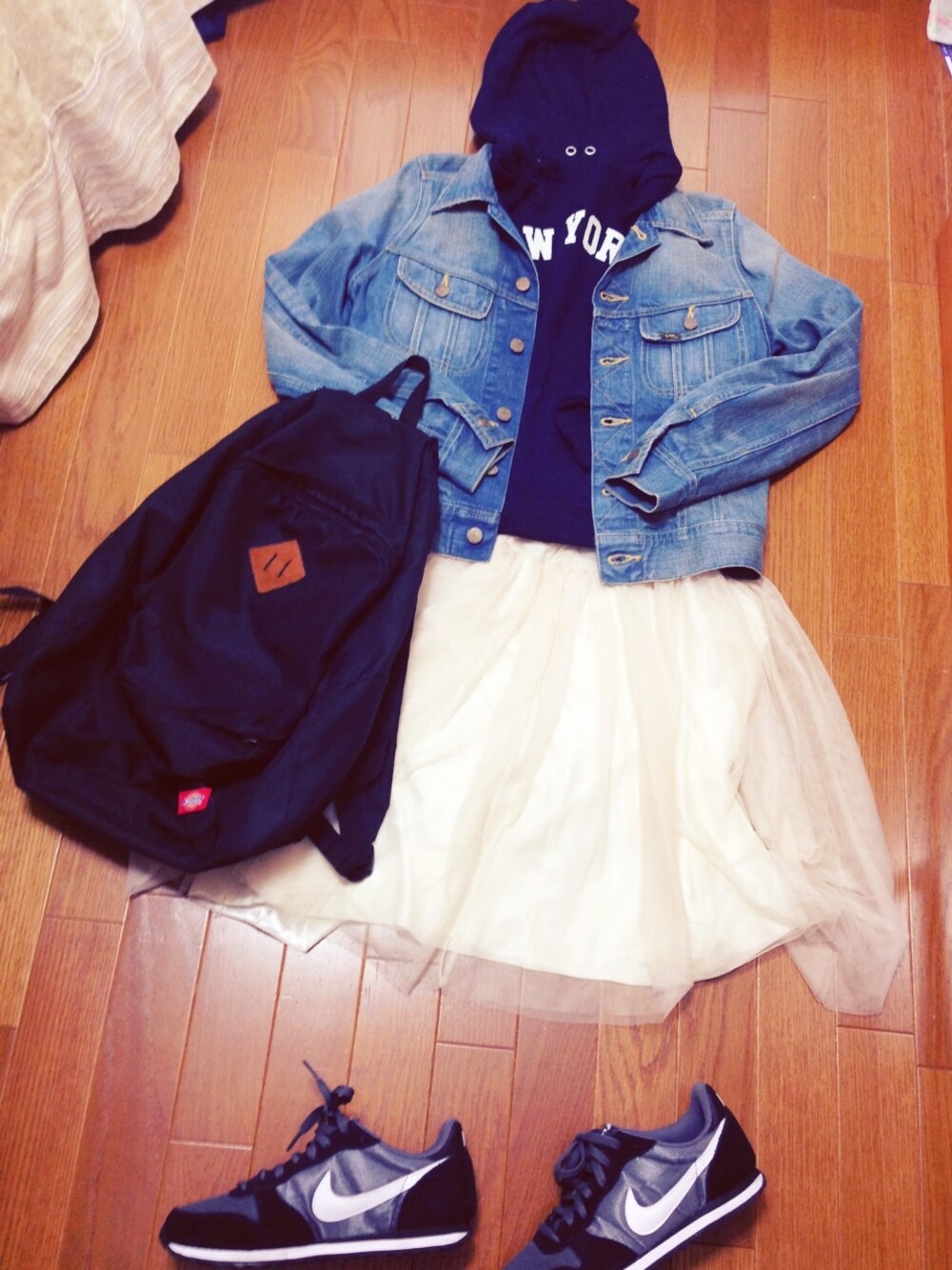 ブルー系のデニムジャケット、ホワイト系のスカート、ブラック系のバックパック/リュックを着用したレディースの春コーディネートの1枚目の写真