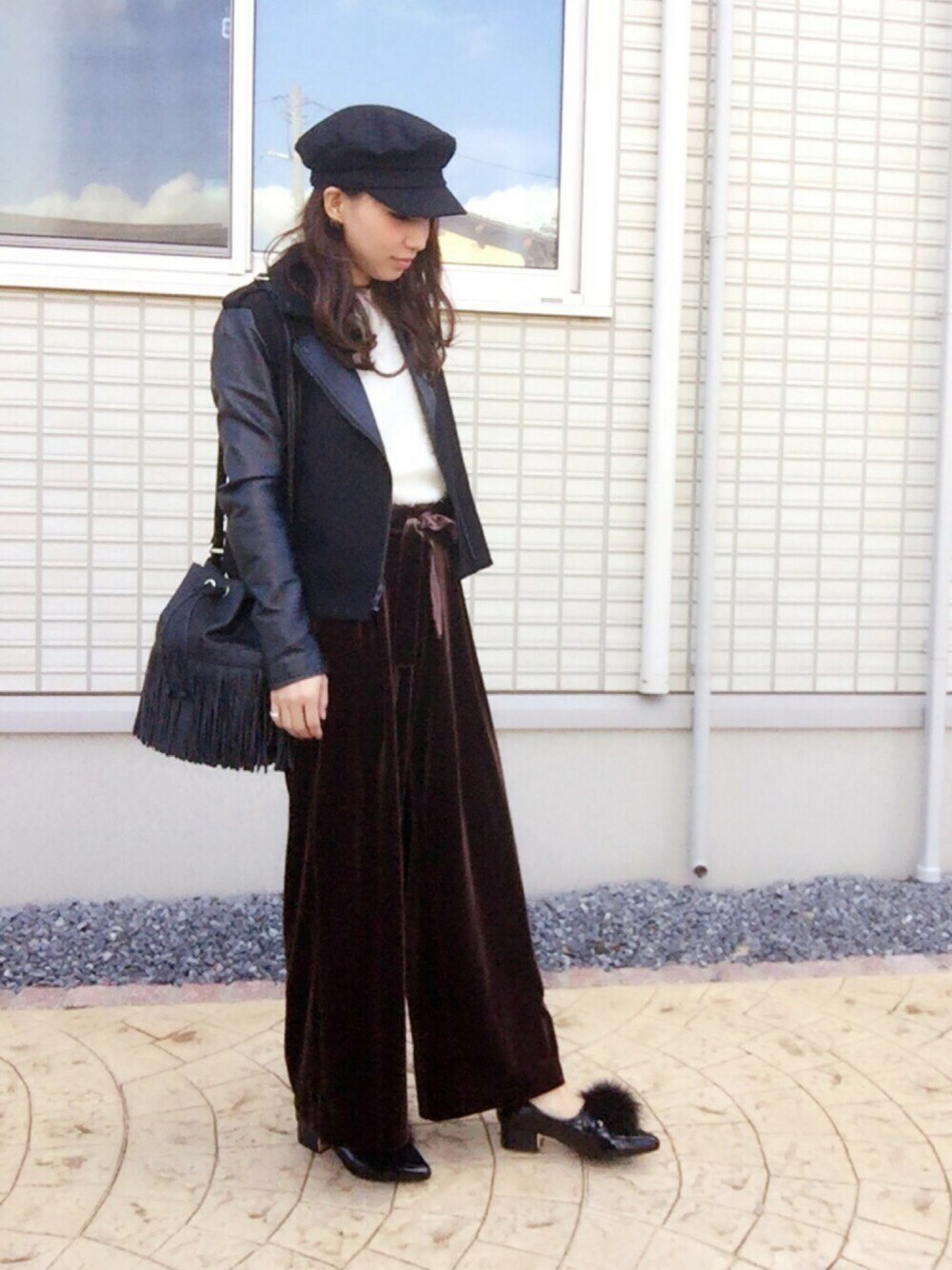 ブラック系のライダースジャケット、ホワイト系のニット/セーター、ブラウン系のその他パンツを着用したレディースの秋コーディネートの1枚目の写真