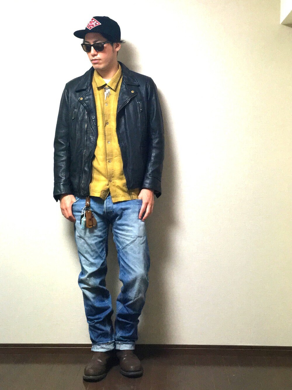 ブラック系のライダースジャケット、イエロー系のシャツ/ブラウス、ブルー系のデニムパンツを着用したメンズの秋コーディネートの1枚目の写真