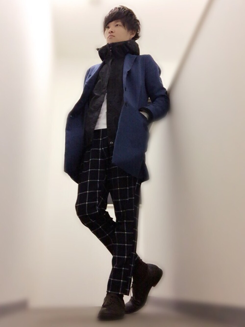 ブルー系のチェスターコート、ホワイト系のTシャツ/カットソー、ブラック系のマウンテンパーカーを着用したメンズの秋コーディネートの1枚目の写真