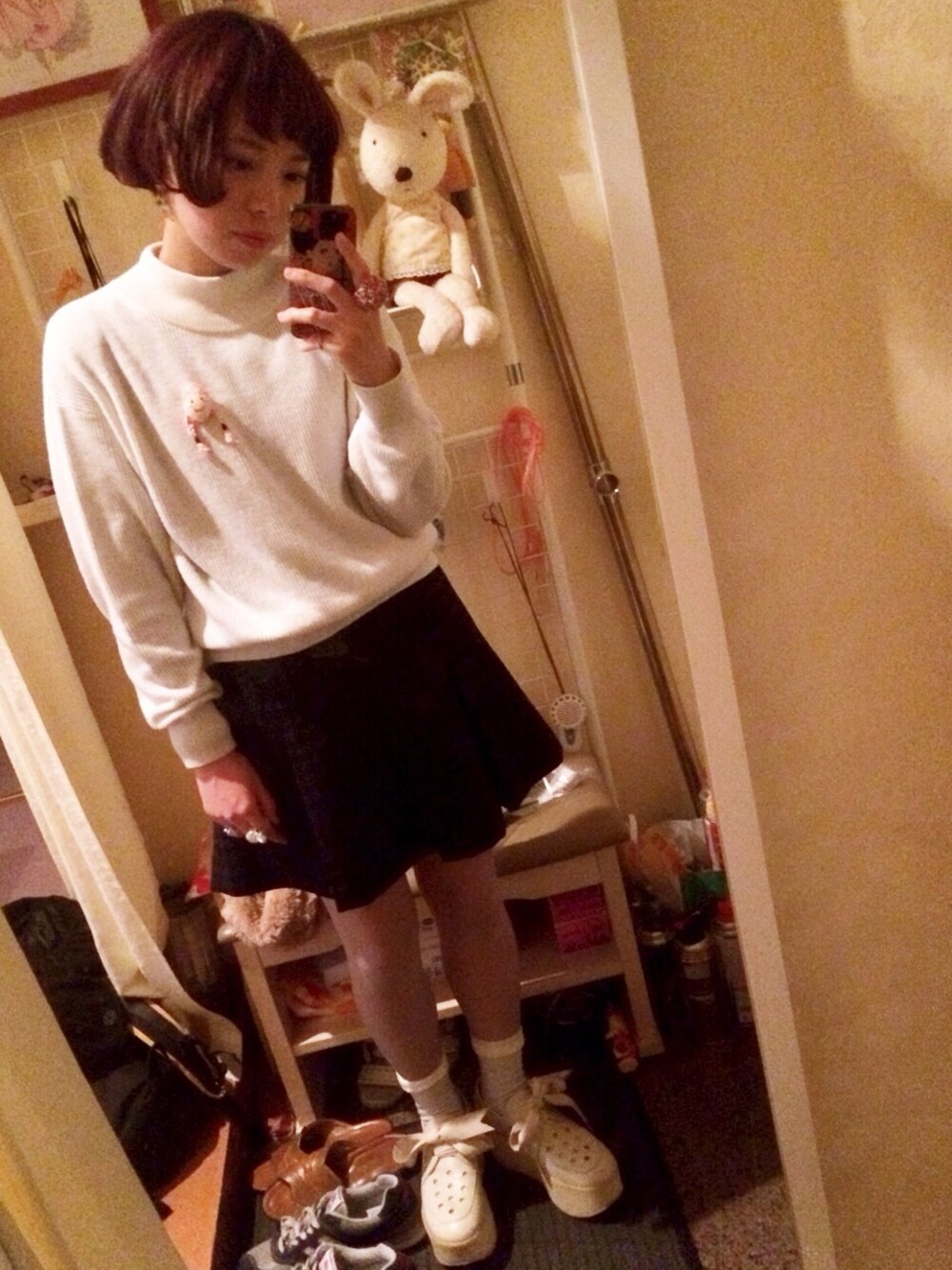 ブラック系のその他アウター、パープル系のスカート、ホワイト系のニット/セーターを着用したレディースの冬コーディネートの1枚目の写真