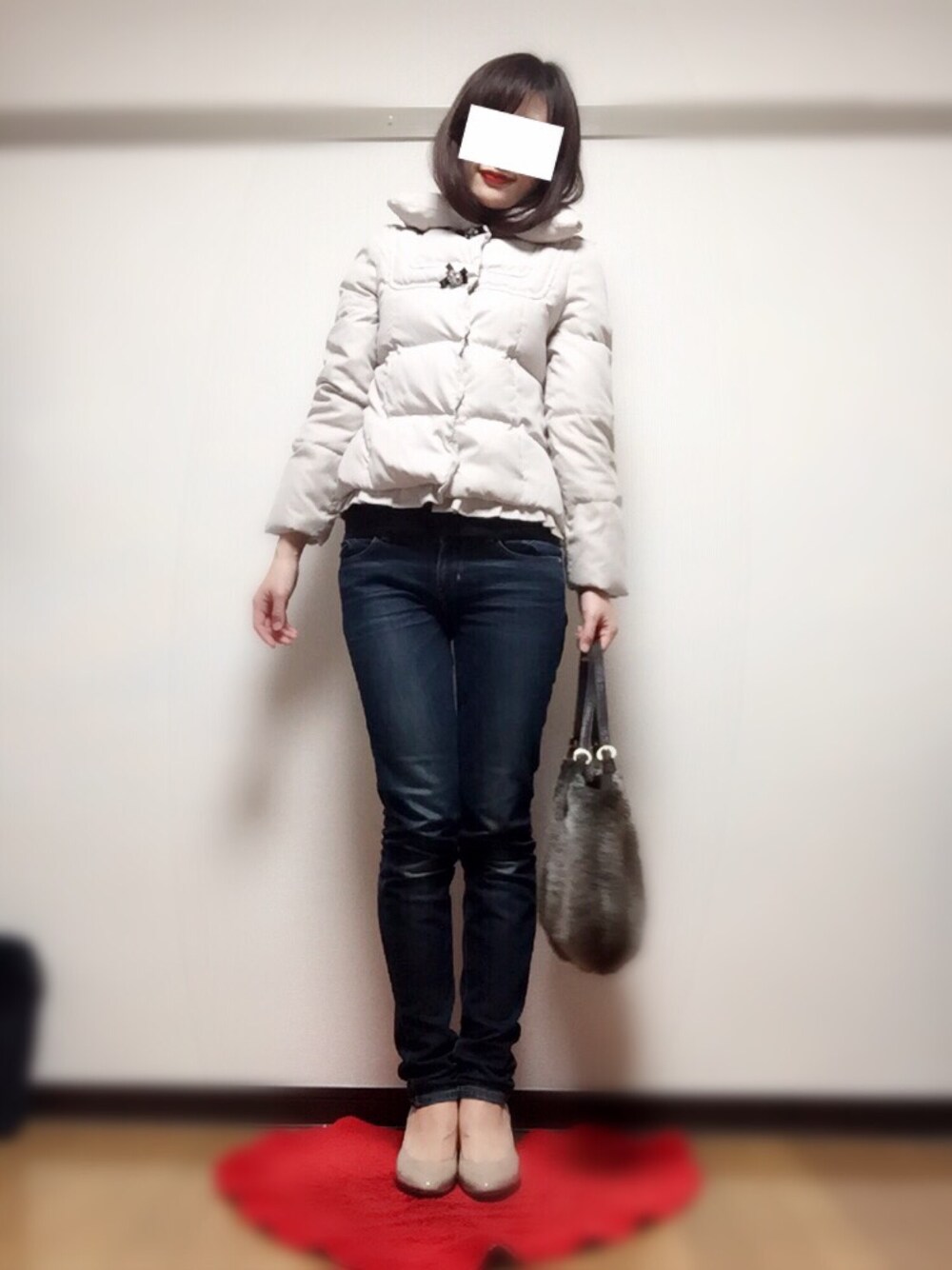 ホワイト系のダウンジャケット/コート、ブルー系のデニムパンツ、ベージュ系のパンプスを着用したレディースの冬コーディネートの1枚目の写真
