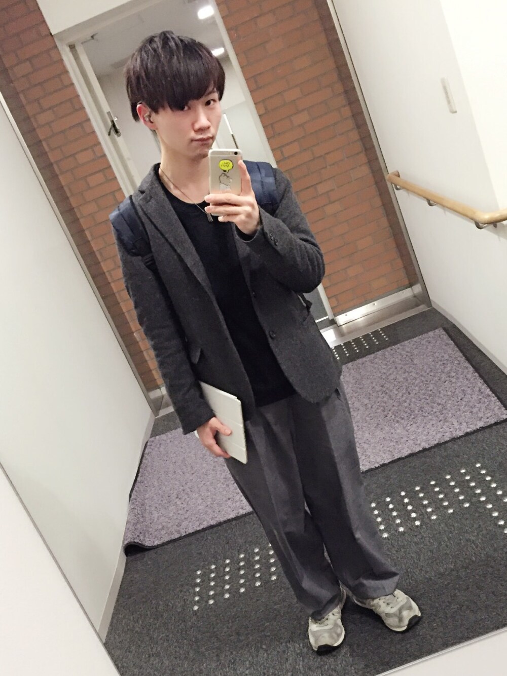 グレー系のスラックス、グレー系のテーラードジャケット、ブラック系のスウェットを着用したメンズの冬コーディネートの1枚目の写真