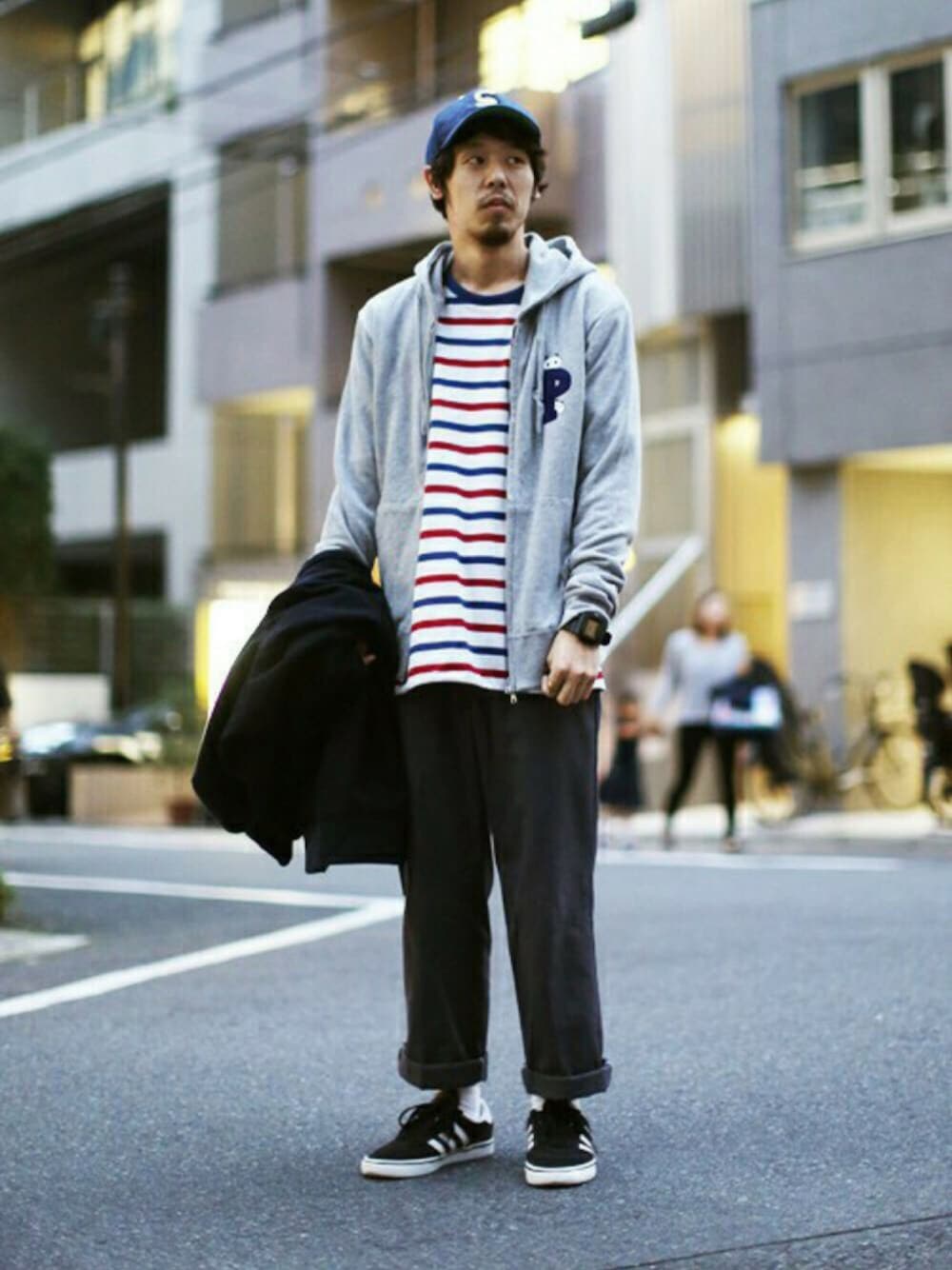 グレー系のパーカー、ブラック系のスニーカー、ブルー系のブルゾンを着用したメンズの秋コーディネートの1枚目の写真